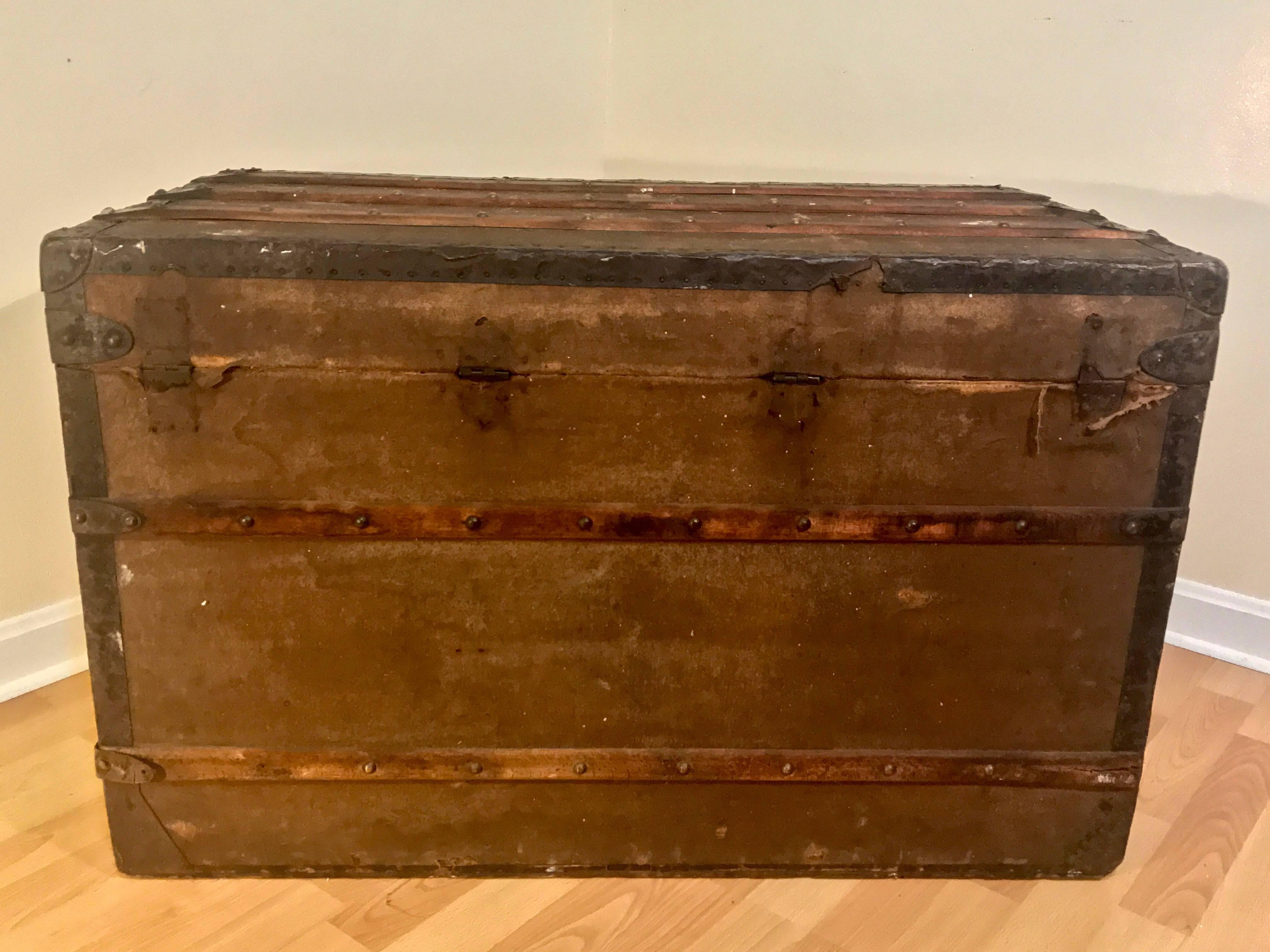 Louis Vuitton canvas steamer trunk, circa 1880 serial #49779 with “A.M Boston” painted on both sides. Front lock similar to LV, but not an original. Interior shelving are not present and some interior ribbon is missing. Top portion appears to have