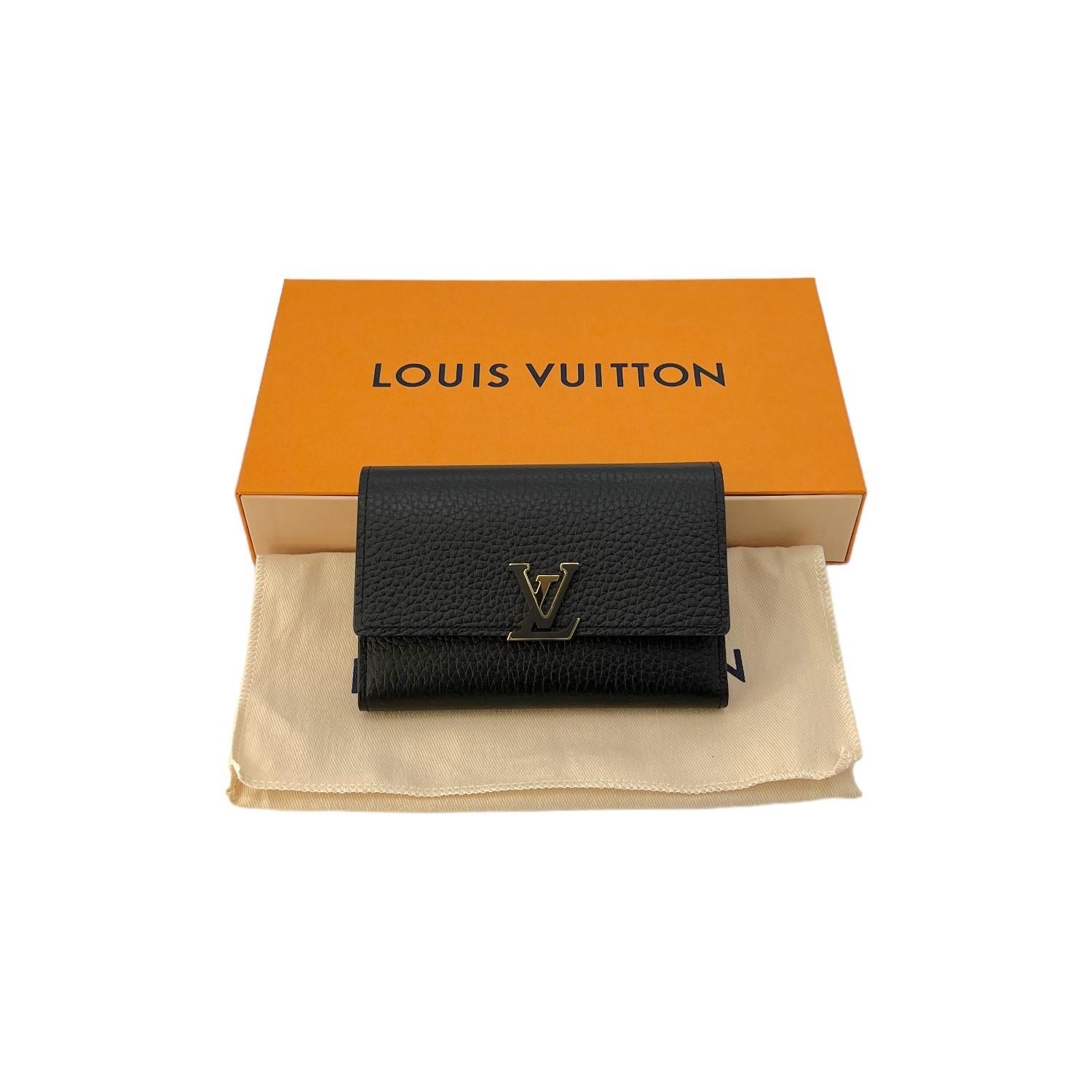 This Louis Vuitton Capucines Compact Wallet was made in France and it is finely crafted of the luxurious black Taurillon leather with gold-tone hardware features. It has a fold over snap closure that opens up to a smooth pink leather interior with 8