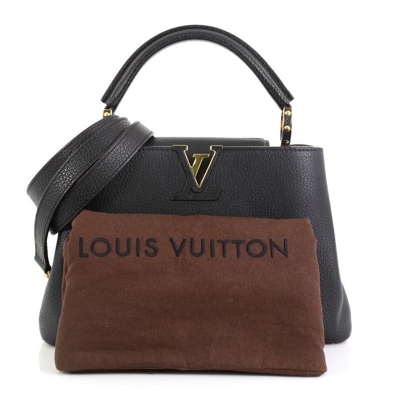 This Louis Vuitton Capucines Handbag Leather BB, crafted from black leather, features a single rolled leather handle, frontal flap with the classic monogram flower, and gold-tone hardware. Its flap opens to a pink leather interior with two open