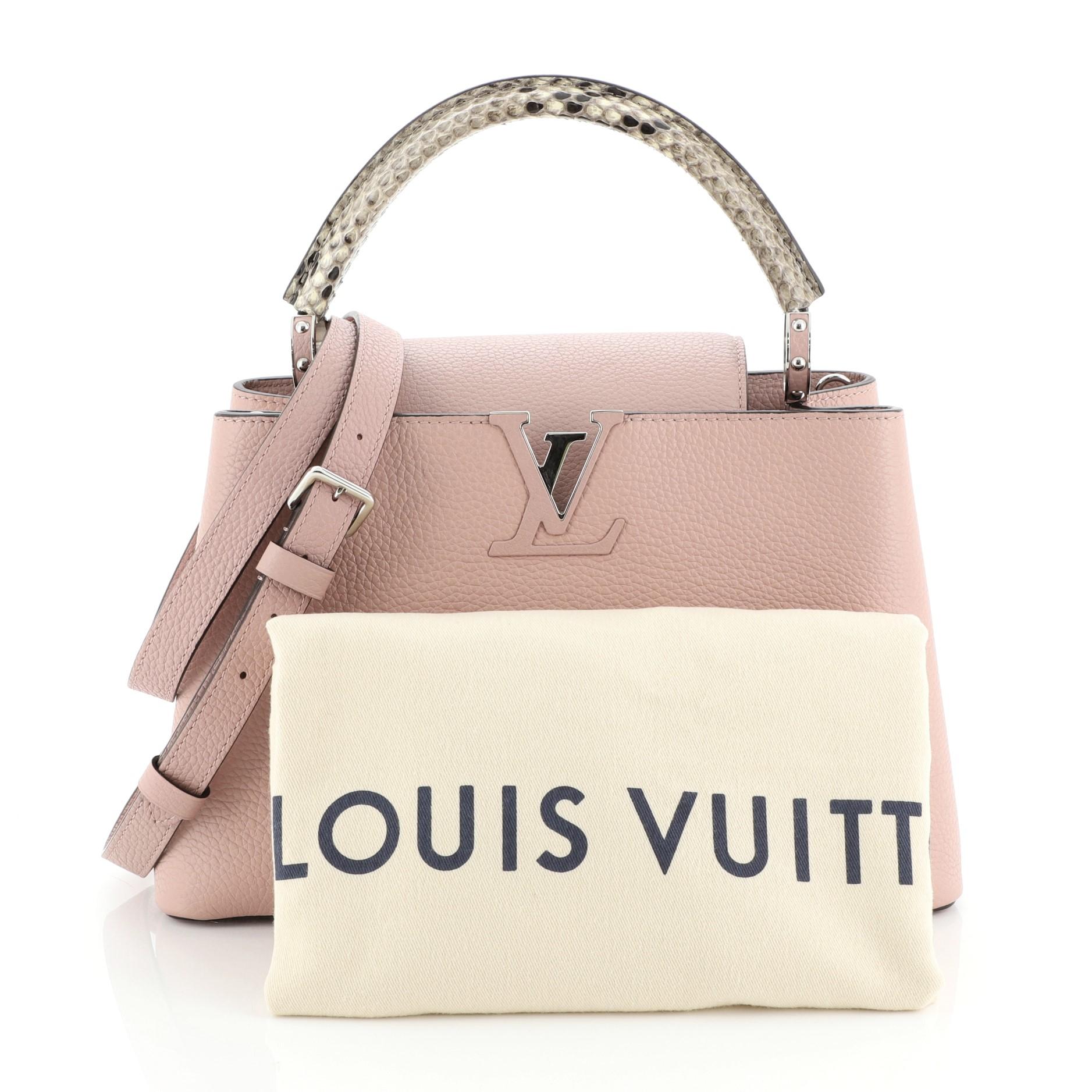 This Louis Vuitton Capucines Handbag Leather with Python PM, crafted from pink leather and genuine python, features a single loop handle with jewel-like rings, frontal flap with monogram flower hardware, and silver-tone hardware. Its center hook