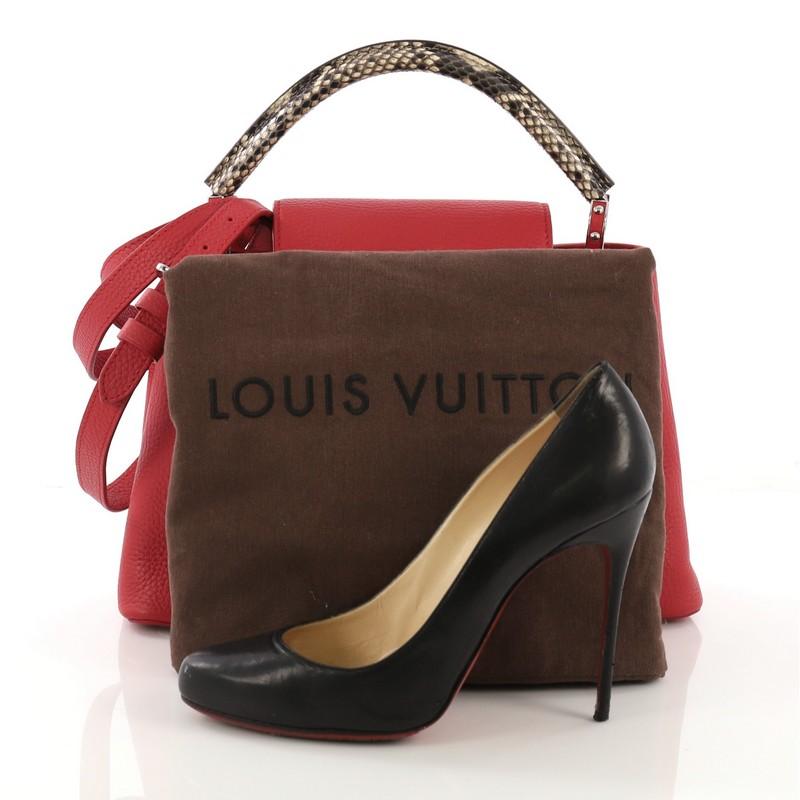 This Louis Vuitton Capucines Handbag Leather with Python PM, crafted in red leather with genuine python, features a single rolled genuine python handle secured by jewel-like rings, frontal flap with the classic monogram flower, and silver-tone