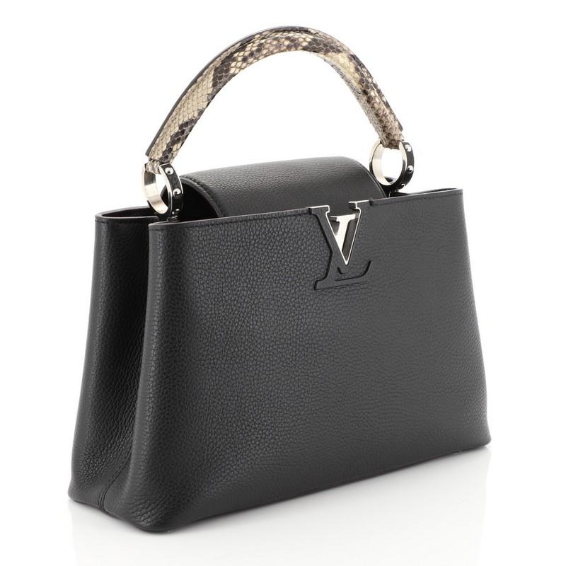 This Louis Vuitton Capucines Handbag Leather with Python PM, crafted from black leather and genuine python, features a single loop handle with jewel-like rings, frontal flap with monogram flower hardware, and silver-tone hardware. Its center hook