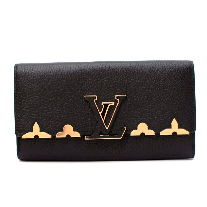  Louis Vuitton Capucines Taurillion Leather Fleur De Monogram Wallet
 

 - Black taurillon leather wallet
 - Flap opening with secured LV closing system featuring gold-tone hardware floral ornaments
 - Opens to: 12 credit card slots, 1 large zipped