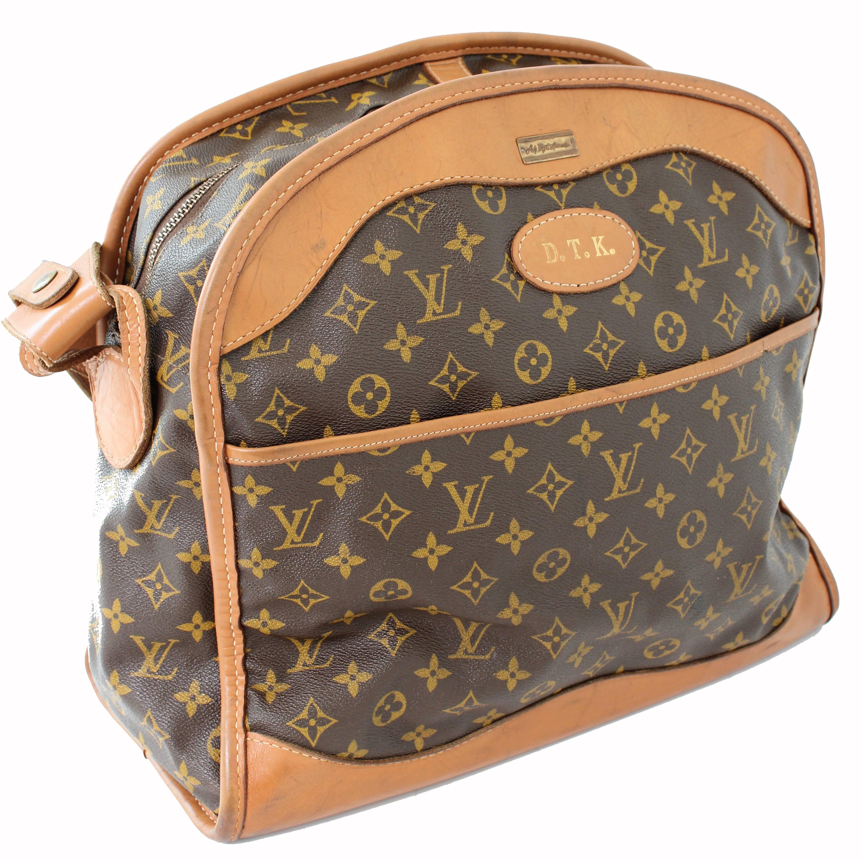 Travel in style with this Louis Vuitton carry on bag, made in the early 1970s. Made from LV's signature monogram canvas, it's trimmed in coated leather and features a flat zipper pocket on one side, an open on the other and an adjustable shoulder