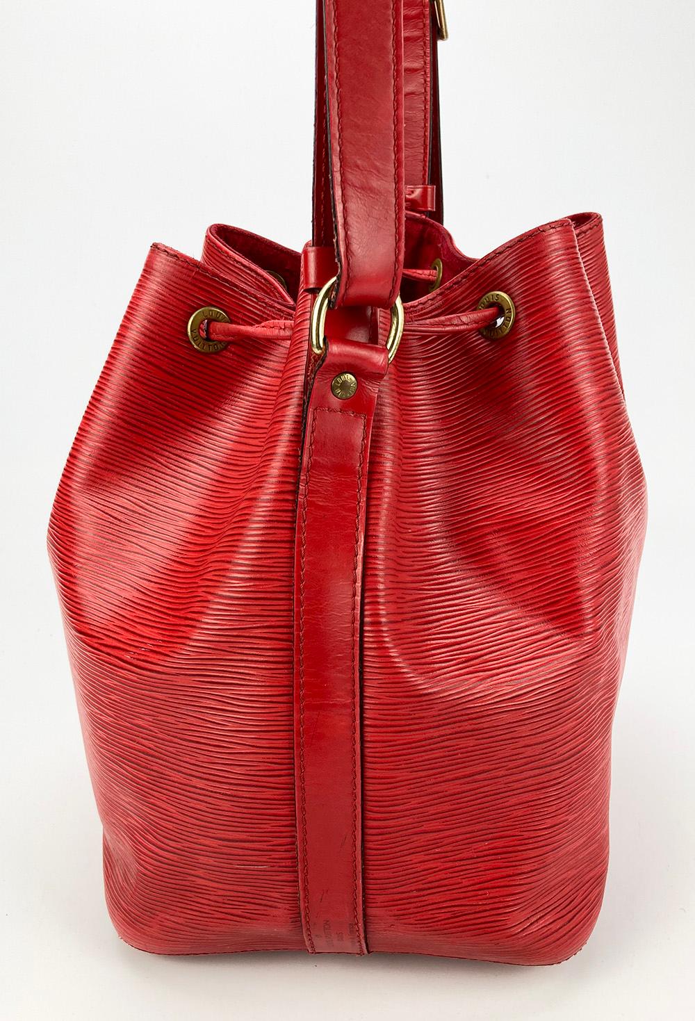 Louis Vuitton Castillian Red Epi Noe Drawstring Bucket Bag in good condition. red epi leather exterior trimmed with gold hardware and leather. top drawstring closure opens to a red suede lined interior. overall good condition. scuffs and scratches