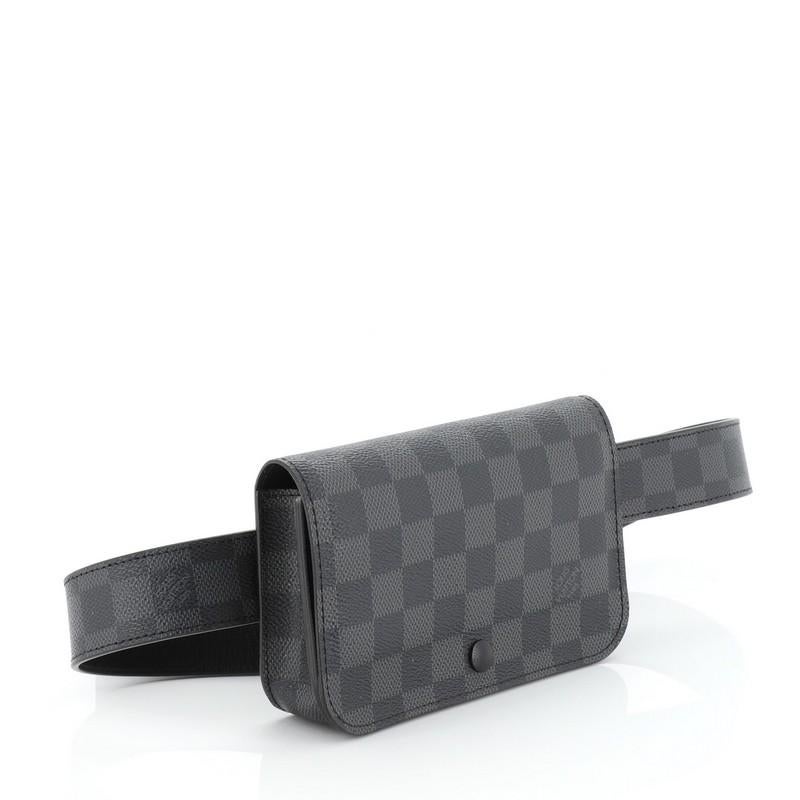 This Louis Vuitton Ceinture Pochette Waist Bag Damier Graphite, crafted from damier graphite coated canvas, features an adjustable belt strap and silver-tone hardware. Its snap button closure opens to a black leather interior. 

Condition: Damaged.