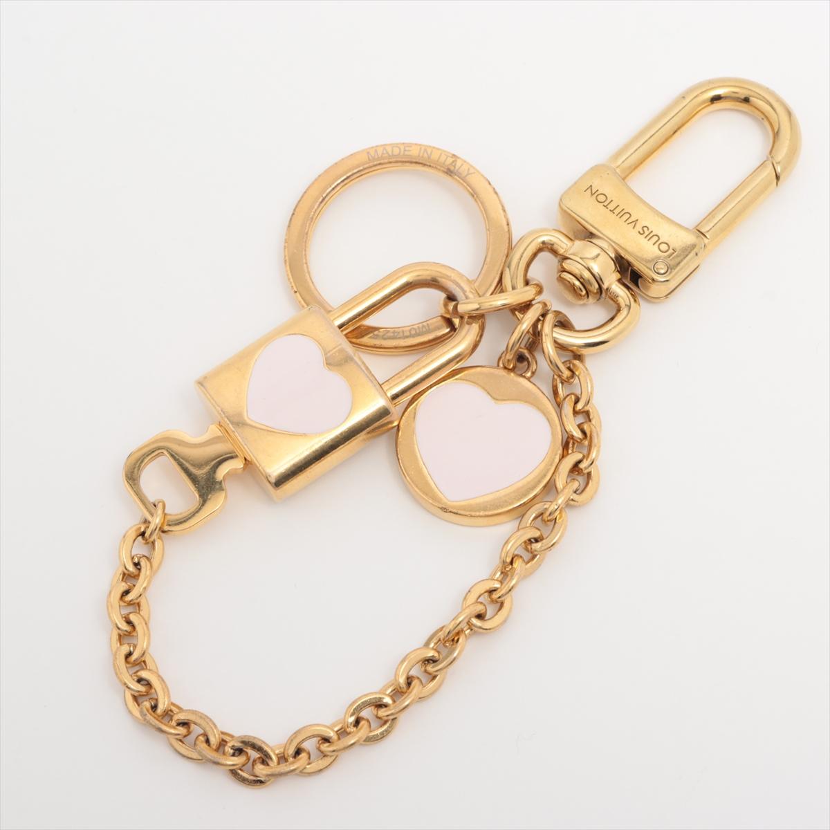 Il charm per borsa Louis Vuitton Chain LV Heart Padlock & Key unisce l'eleganza iconica e il romanticismo giocoso in uno scintillante metallo dorato. Un lucchetto, con inciso un cuore, penzola insieme alla chiave coordinata, entrambi sospesi a una