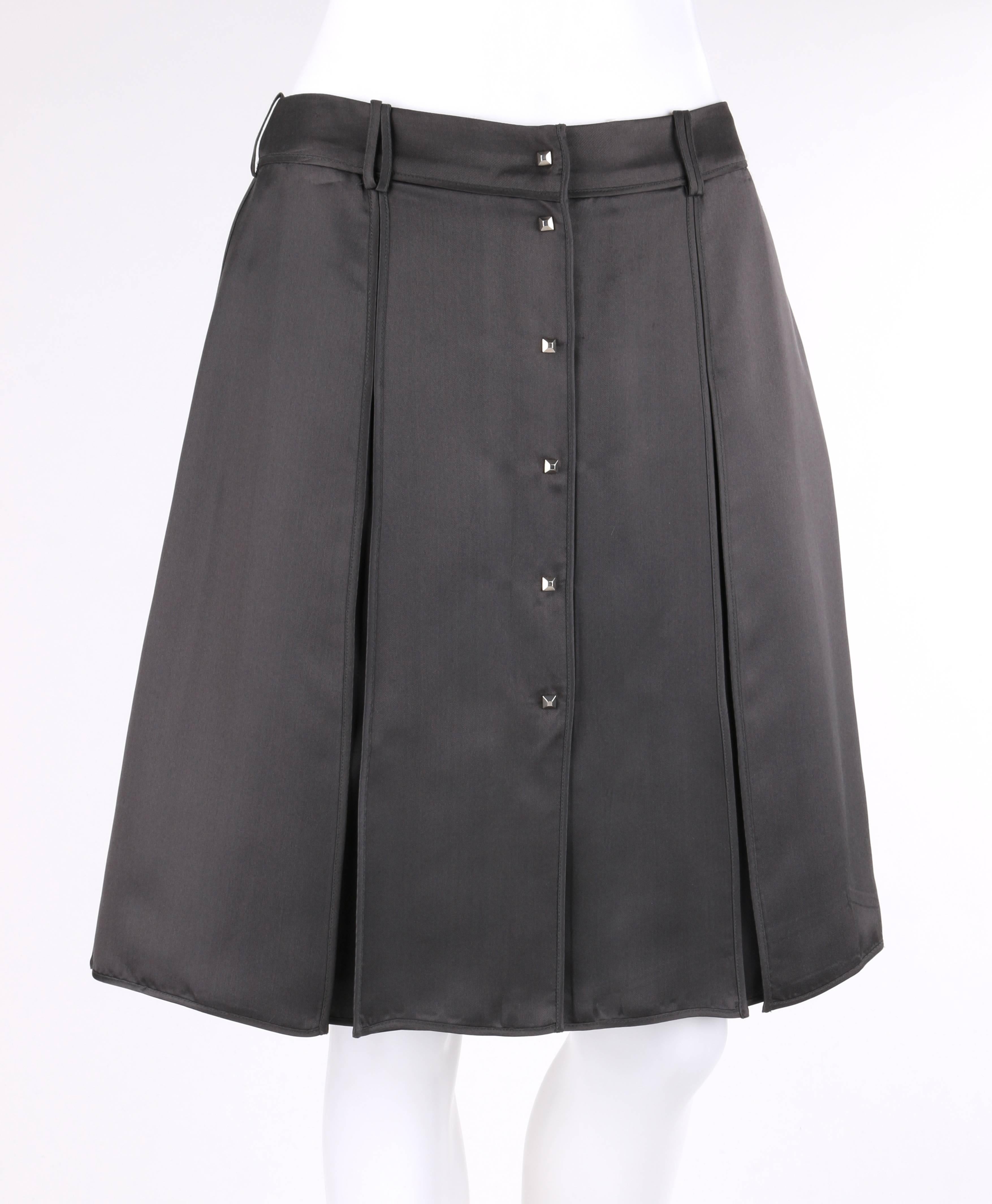 Louis Vuitton charcoal gray silk satin studded pleated wrap skirt. Charcoal gray silk satin. Two front and back large inverted box pleats. Banded waistline with six belt loops. Six center front silver-toned pyramid stud snap closures. Bias bound