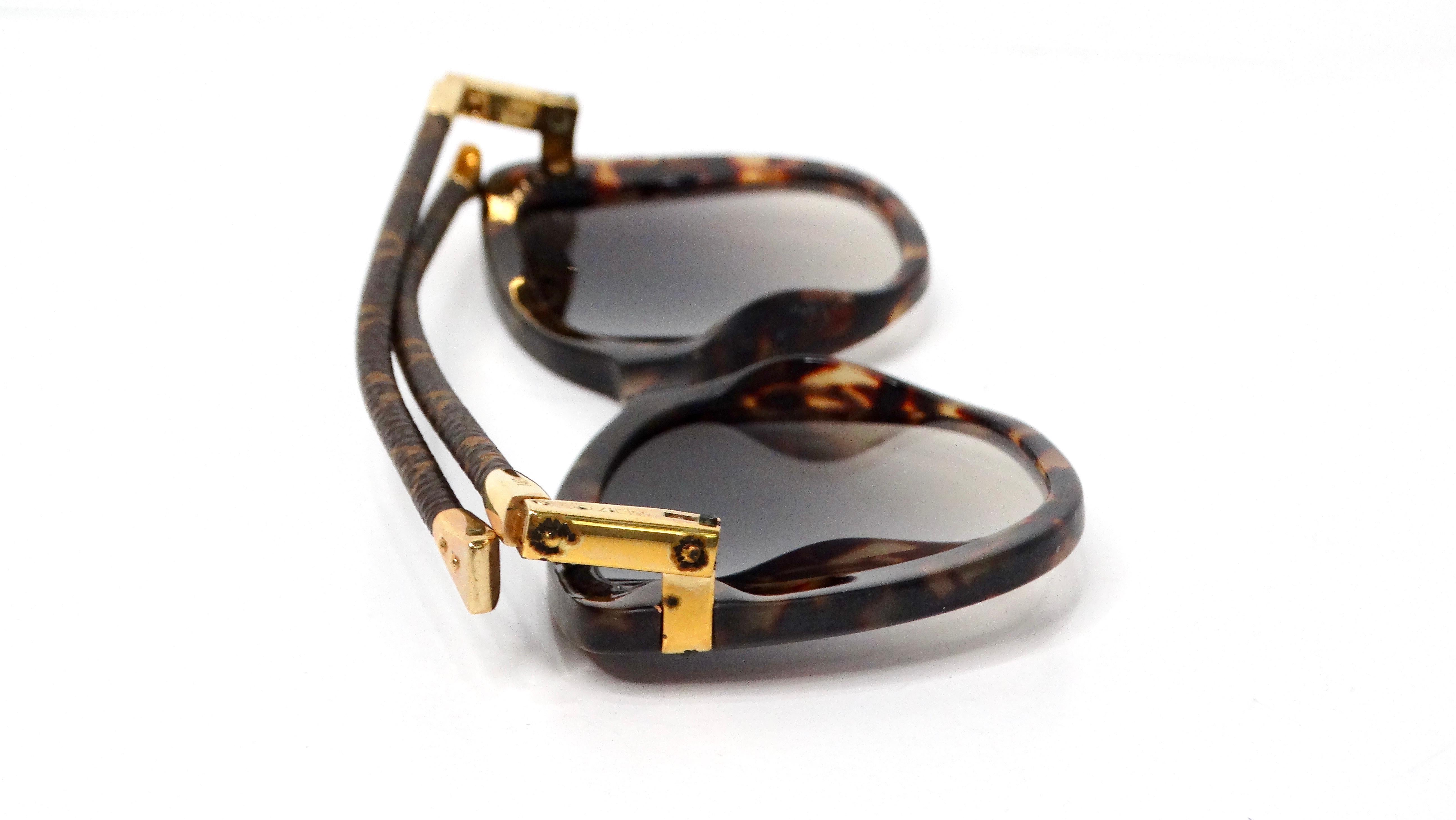 Les lunettes de soleil pliables Louis Vuitton Charlotte Frame Tortoise Acetate Monogram sont un mélange étonnant de design classique et de fonctionnalité moderne. Dotées d'une monture marron tortue foncé, ces lunettes de soleil exsudent la