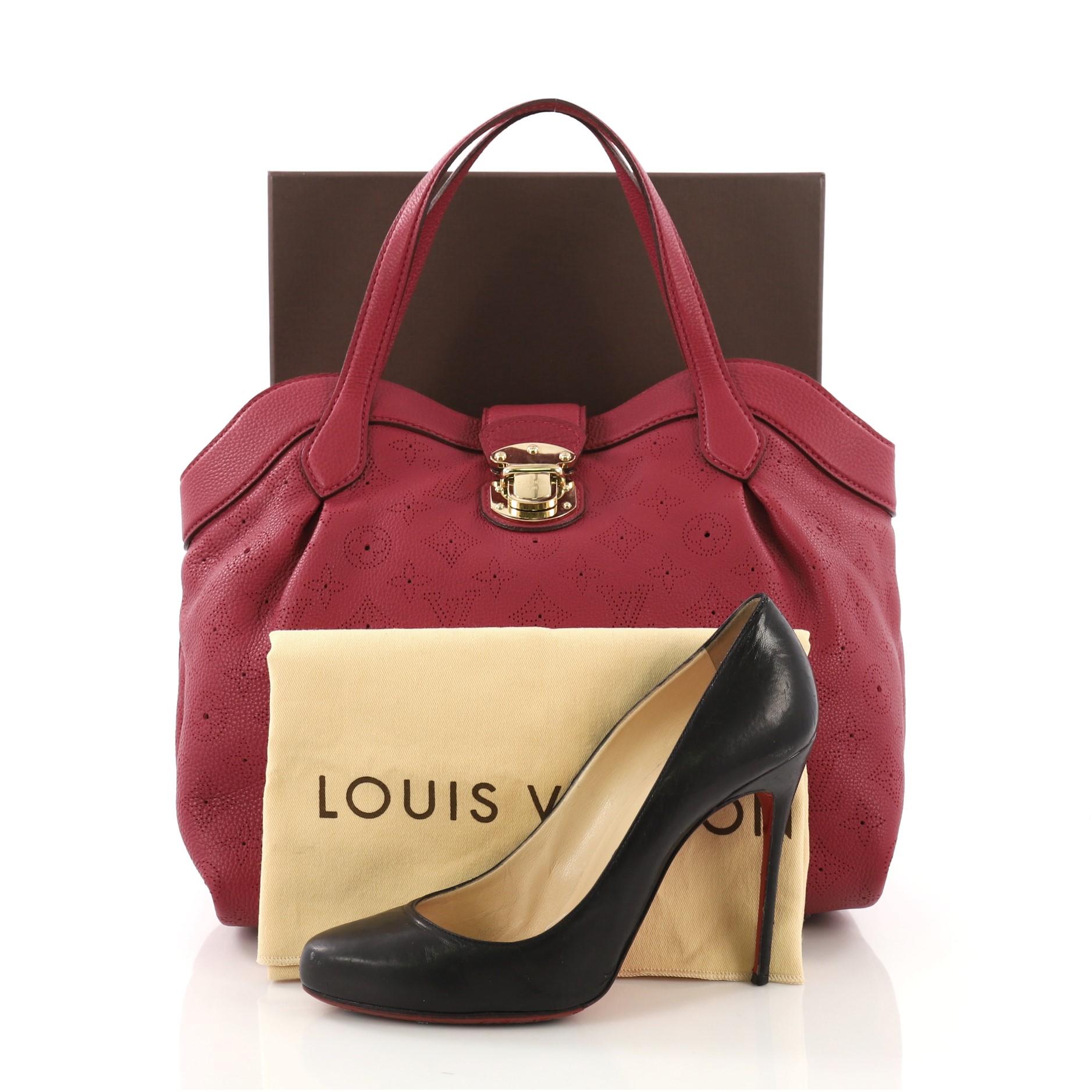 This Louis Vuitton Cirrus Handbag Mahina Leather PM, crafted from dark pink mahina leather, features dual flat leather handles, protective base studs, and gold-tone hardware. Its flap tab push-lock closure opens to a gray microfiber interior with