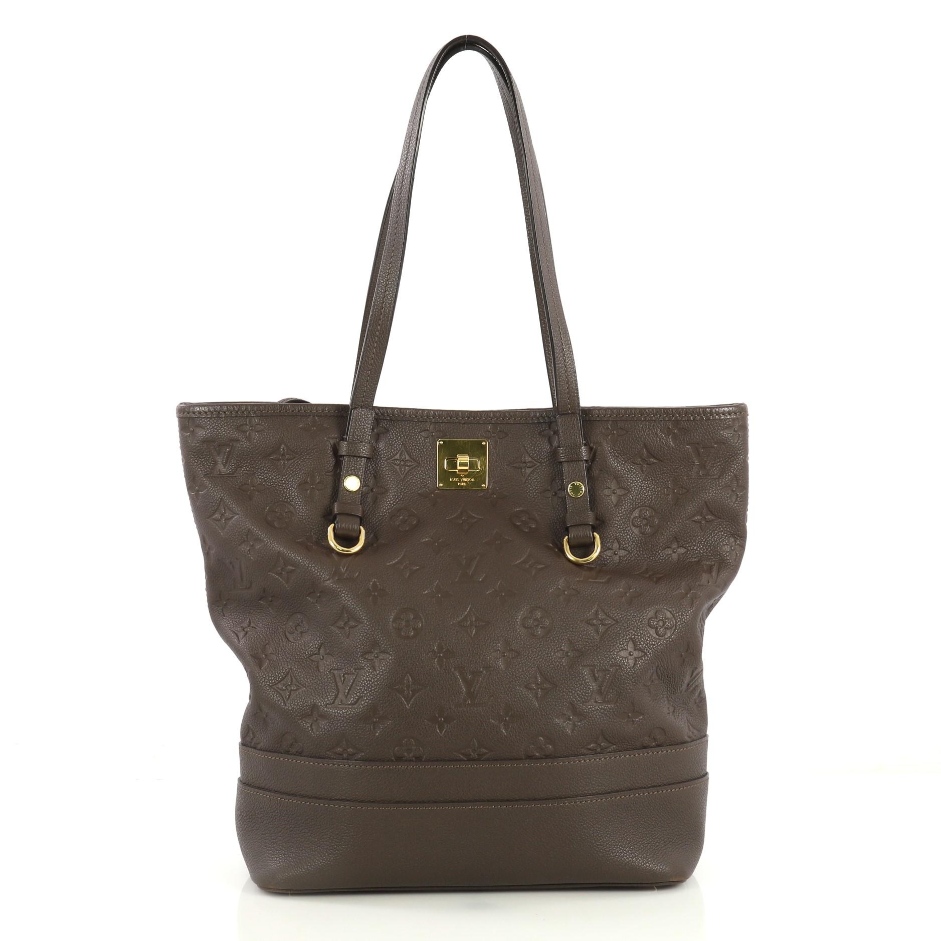 This Louis Vuitton Citadine Handbag Monogram Empreinte Leather PM, crafted in brown monogram empreinte leather, features dual slim handles, protective base studs, and gold-tone hardware. Its turn-lock closure opens to a brown fabric interior with