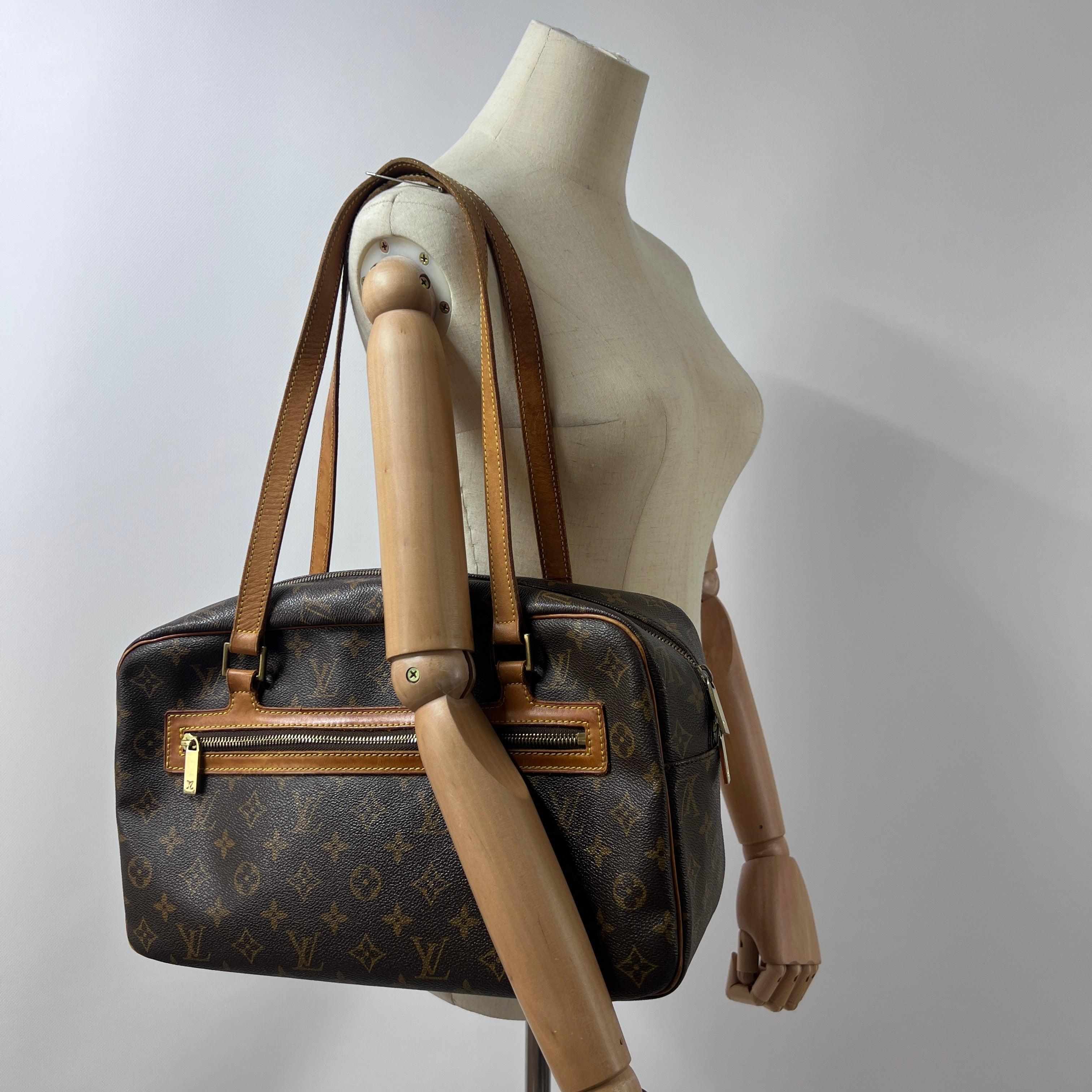 Cité MM in monogram canvas with gold-tone hardware. Top zip; exterior pocket; organized interior. Date code FL1002 (2002), France. Condition: excellent. Dimensions: 37 × 21 × 10 cm.