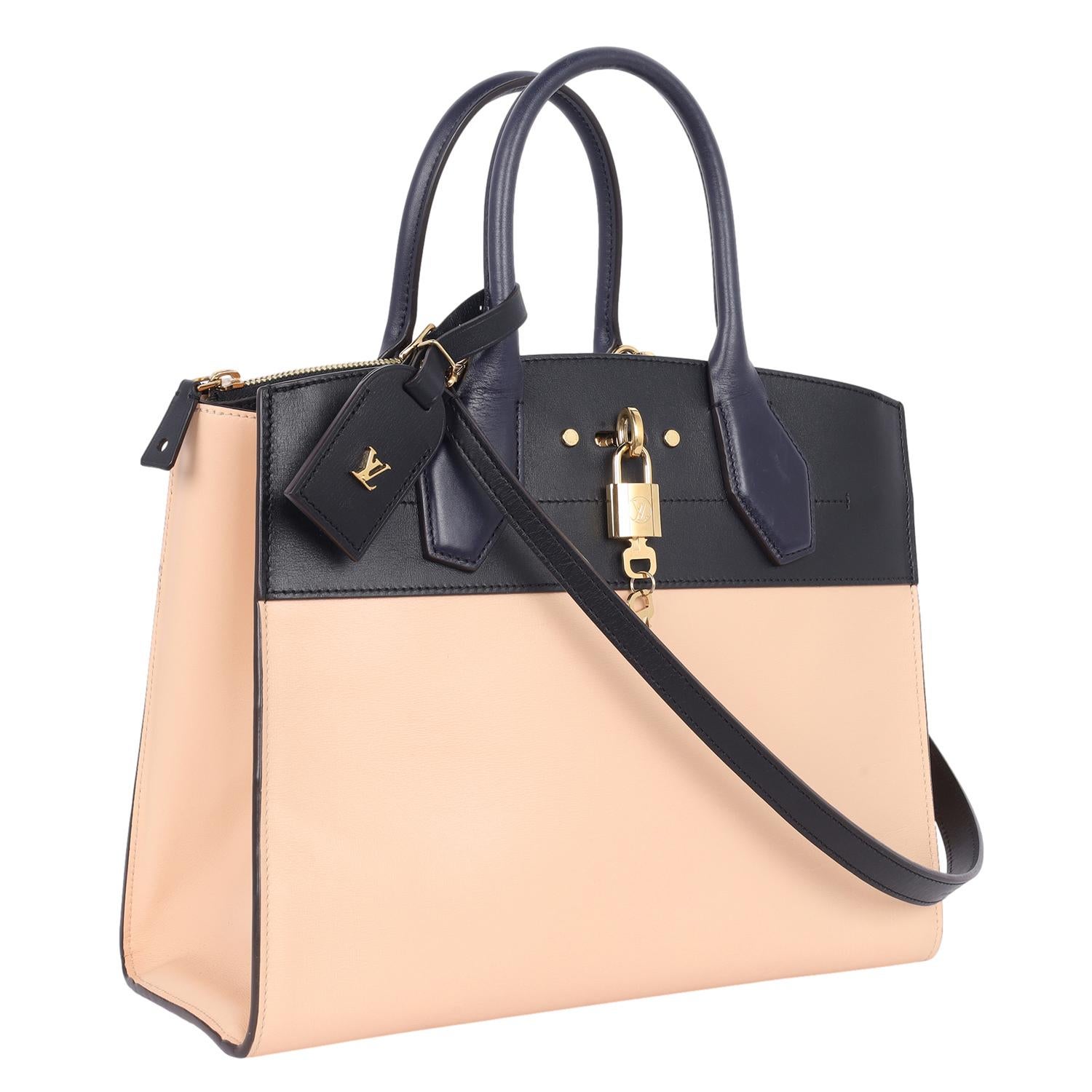 Authentic Louis Vuitton city steamer 2way satchel in very dark blue and beige. Features toron handles with dora handle mounts, very dark blue almost black color, nametag with the metallic LV signature, engraved and facetted padlock, LV circle