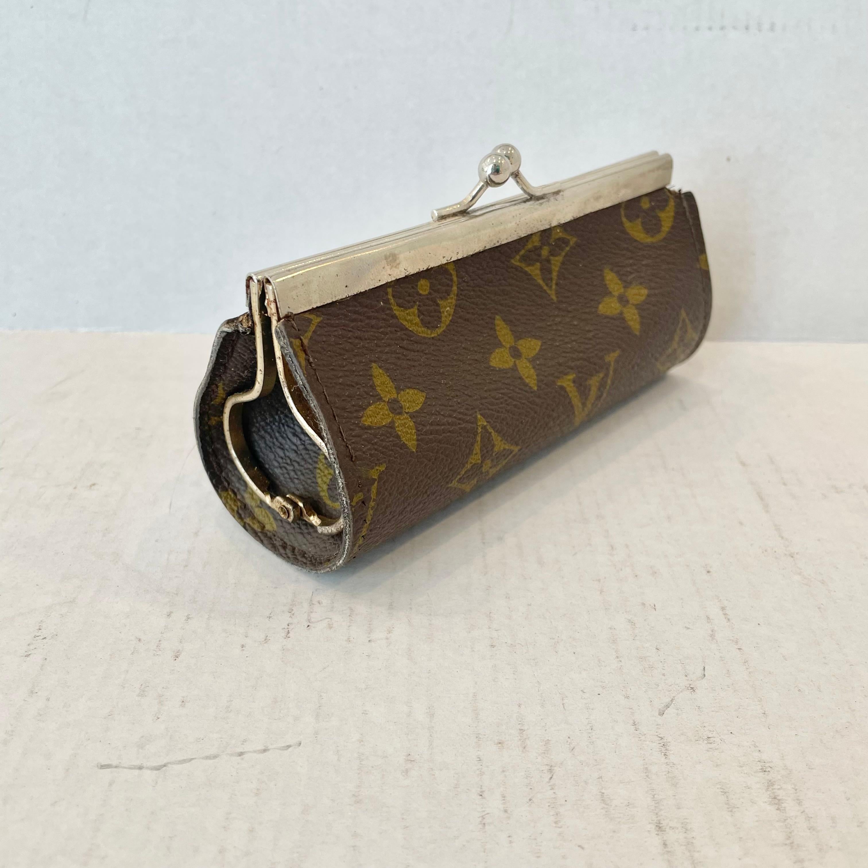 Louis Vuitton coin purse from the 1950s. Perfect for change, lipstick and other small items in your bag. The case is made of the the iconic Louis Vuitton monogram canvas with metal clasp closure and hardware. Good vintage condition with wear as