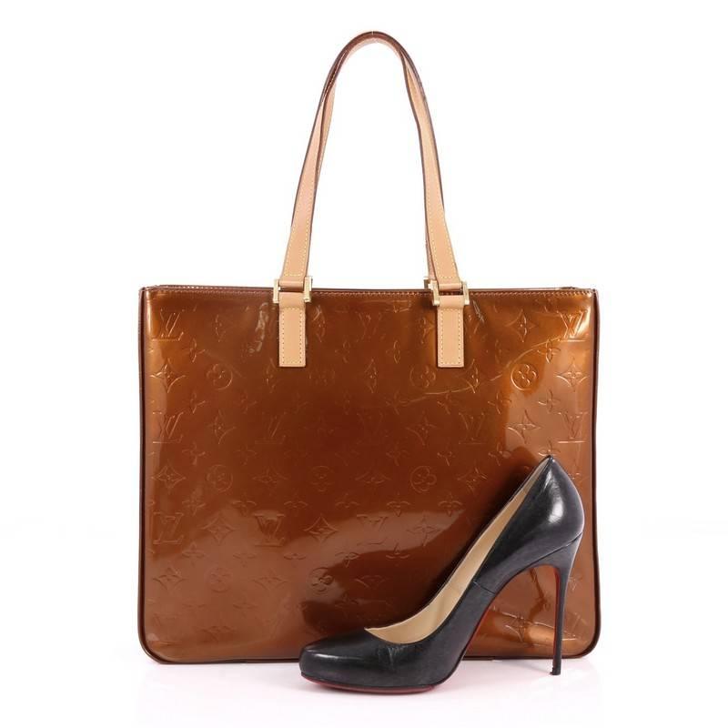 This authentic Louis Vuitton Columbus Handbag Monogram Vernis is great for fashionistas on-the-go. Crafted in brown monogram vernis leather, this stunning bag features dual-flat leather handles, natural cowhide leather trims, and gold-tone hardware