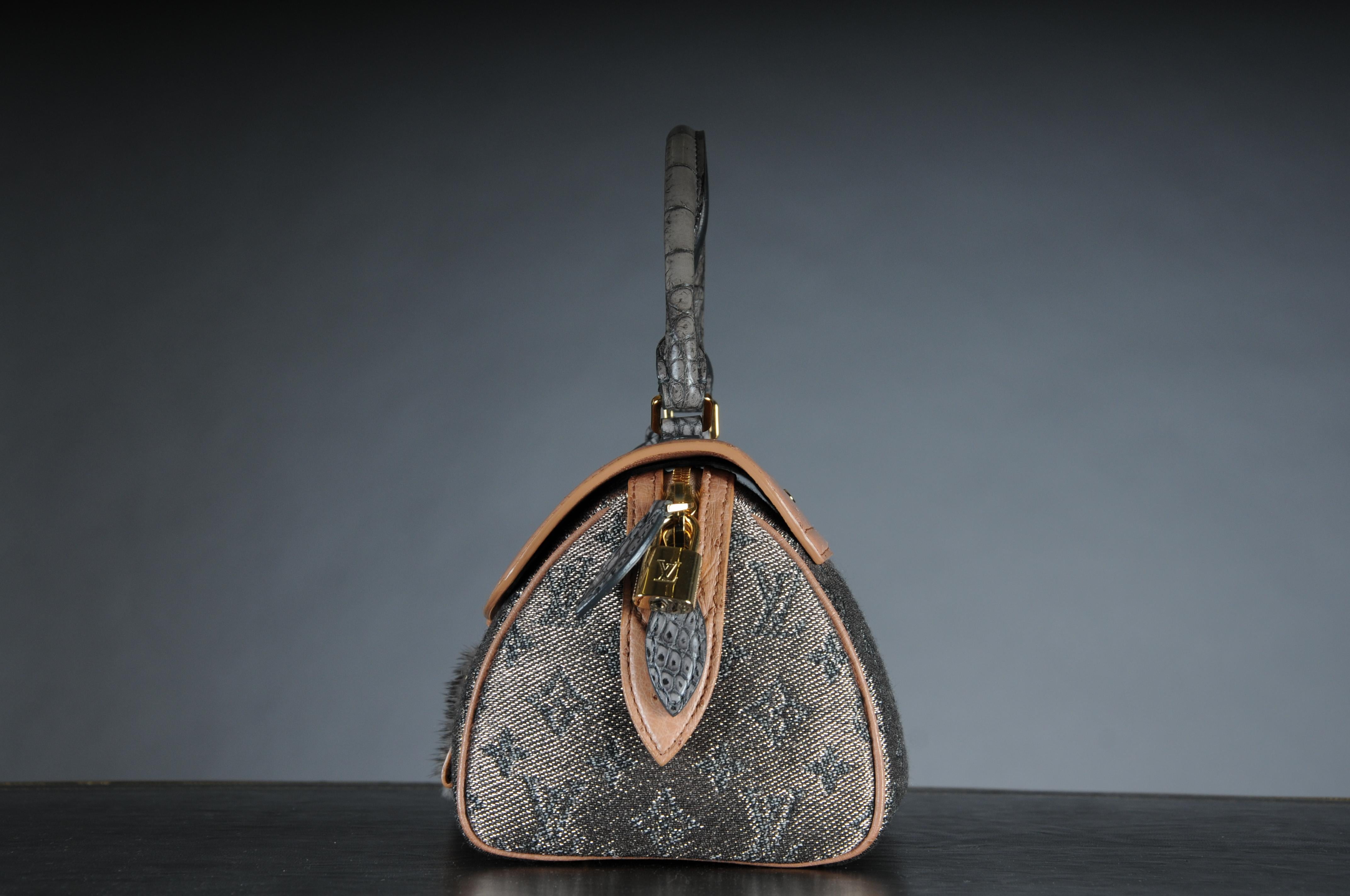 Ikonische Louis Vuitton Tasche, Modell Comédie Carousel, Produktionsjahr 2010/2011, aus Lurexstoff mit Ledereinsätzen und goldenen Beschlägen. Ausgestattet mit einem Reißverschluss und einer silbernen Lederfrontklappe mit Verschlusshaken.