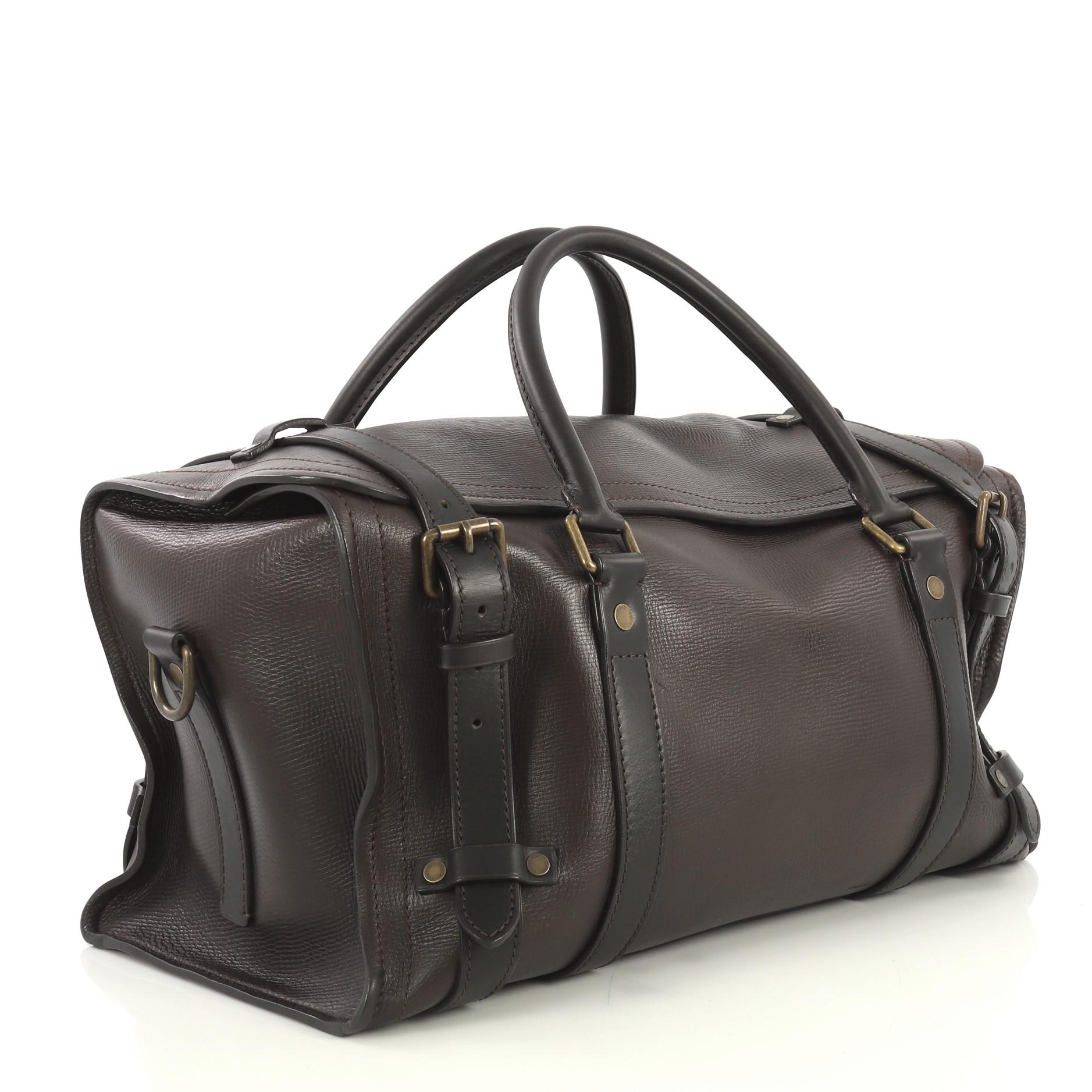 This Louis Vuitton Commanche Handbag Utah Leather, crafted from brown leather, features dual rolled leather handles with links, full rear patch pocket and antique brass-tone hardware. Its zip closure opens to a brown fabric interior with zip pocket.