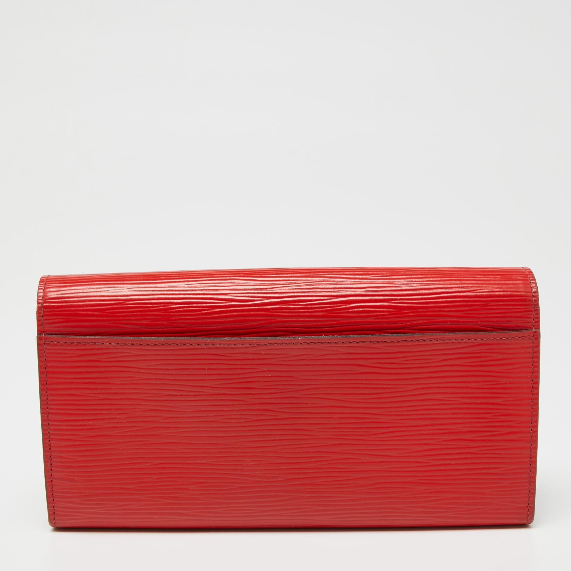 One of the most famous wallets by Louis Vuitton is the Sarah. This one here comes made from Epi leather and the button on the flap opens to an interior with multiple card slots and a zip pocket. Perfect in size, this wallet can easily fit inside