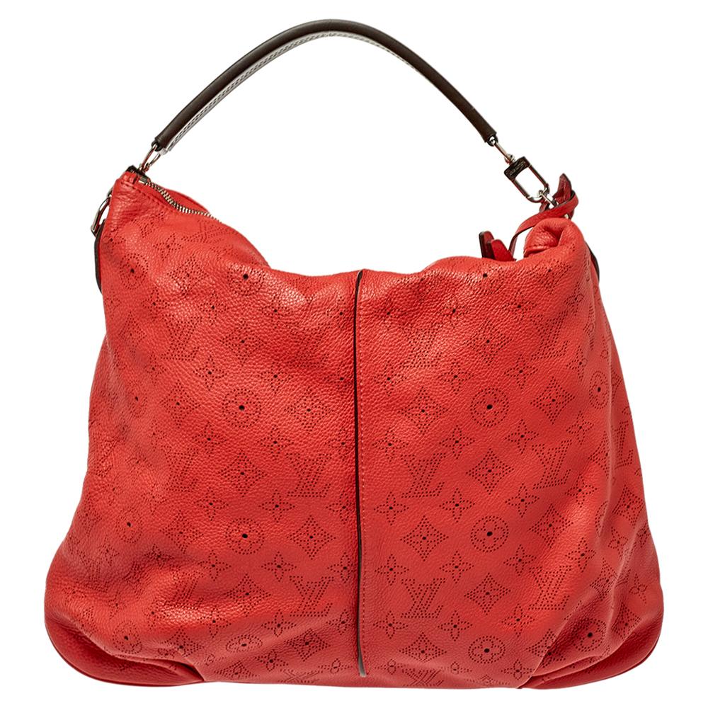 Crafted from Mahina leather, this red Selene bag from Louis Vuitton features a monogram pattern all over. The bag comes with a top handle, a padlock, a key clochette, and a detachable shoulder strap. The zip-top closure opens to an Alcantara-lined