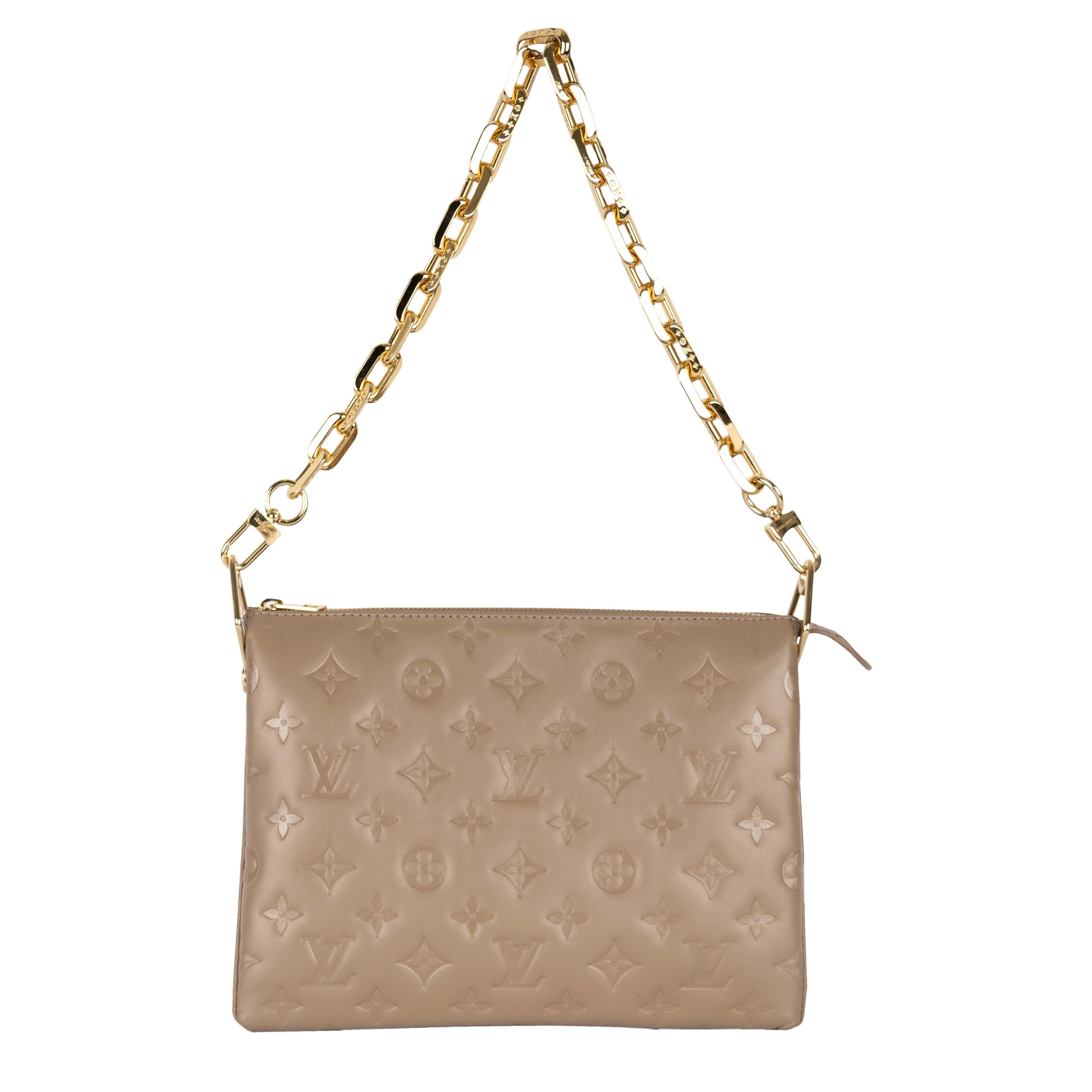 Louis Vuitton Coussin PM bag in a taupe champagne color with a metallic sheen. The bag features LV monogram embossed on the puffy lambskin leather. It has a zippered top which opens to three compartments inside making it a spacious bag to hold all