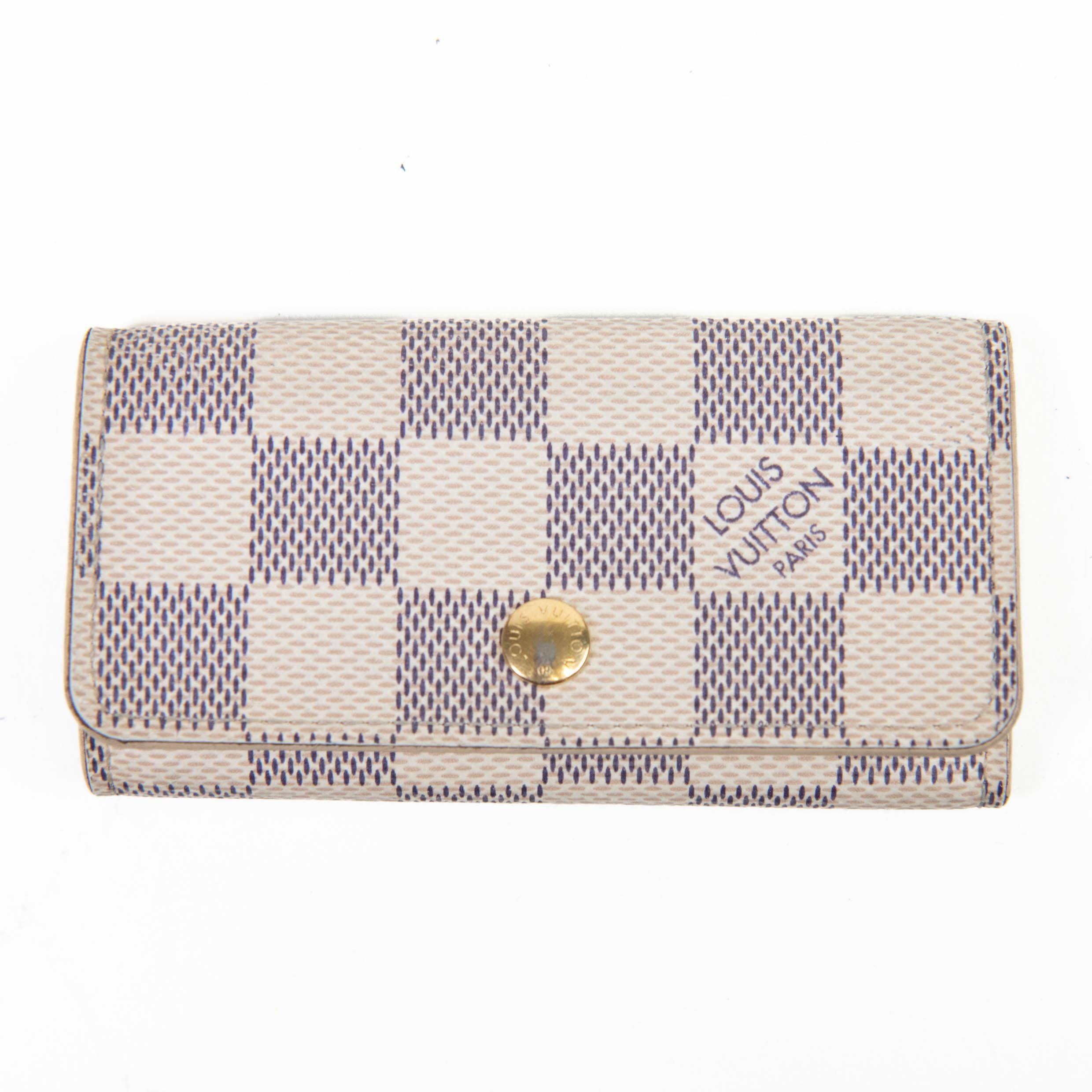 100% Authentic

This stylish key holder is crafted of Louis Vuitton Damier Azur canvas. The case opens with a snap to an ivory cross-grain leather interior with six brass key rings. Once the keys are in place, the sides snap shut around the keys