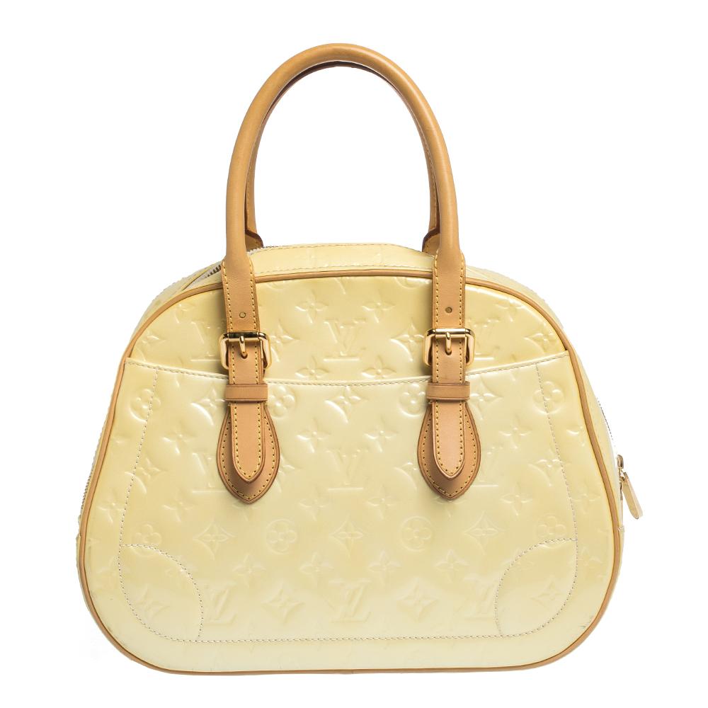 Well-made and essaying luxury, this Louis Vuitton bag will take you through your day with ease. Crafted from the brand's Monogram Vernis leather, it features dual tan leather handles and exterior slip pockets. The cream bag is secured by a wide