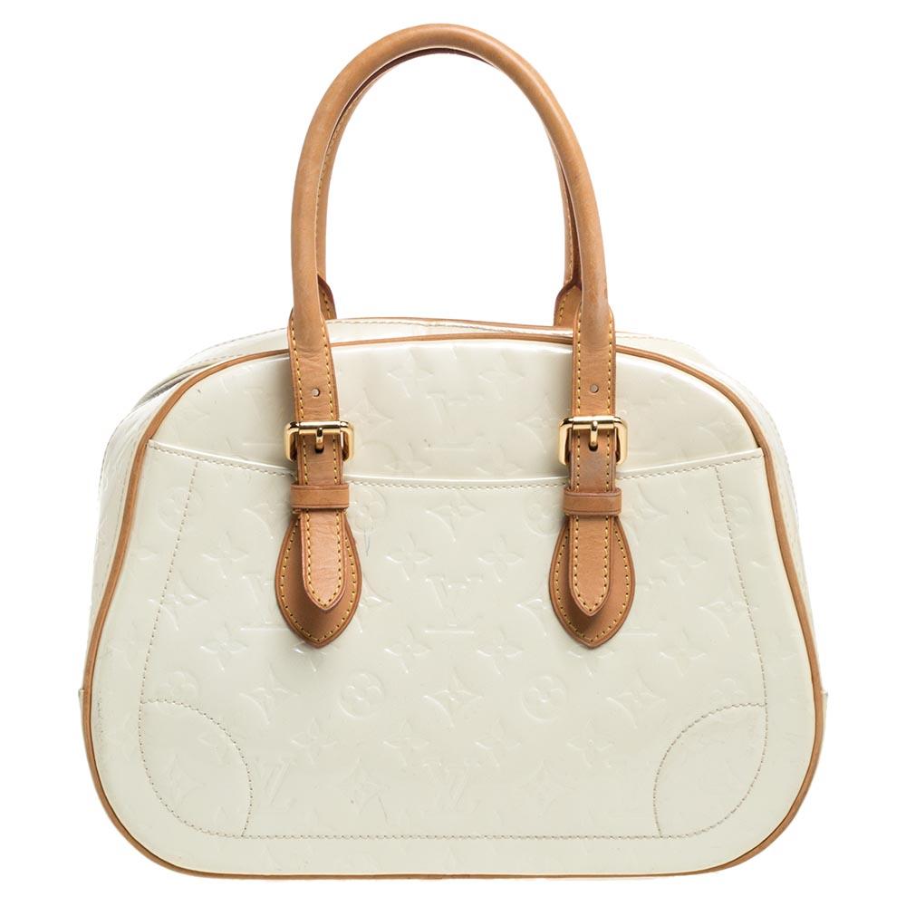 Elegant and polished, this bag takes you through your day with ease. Crafted in a smart silhouette from Monogram Vernis leather, it comes in a stunning shade of cream. The bag features dual-rolled handles and exterior slip pockets. The bag is
