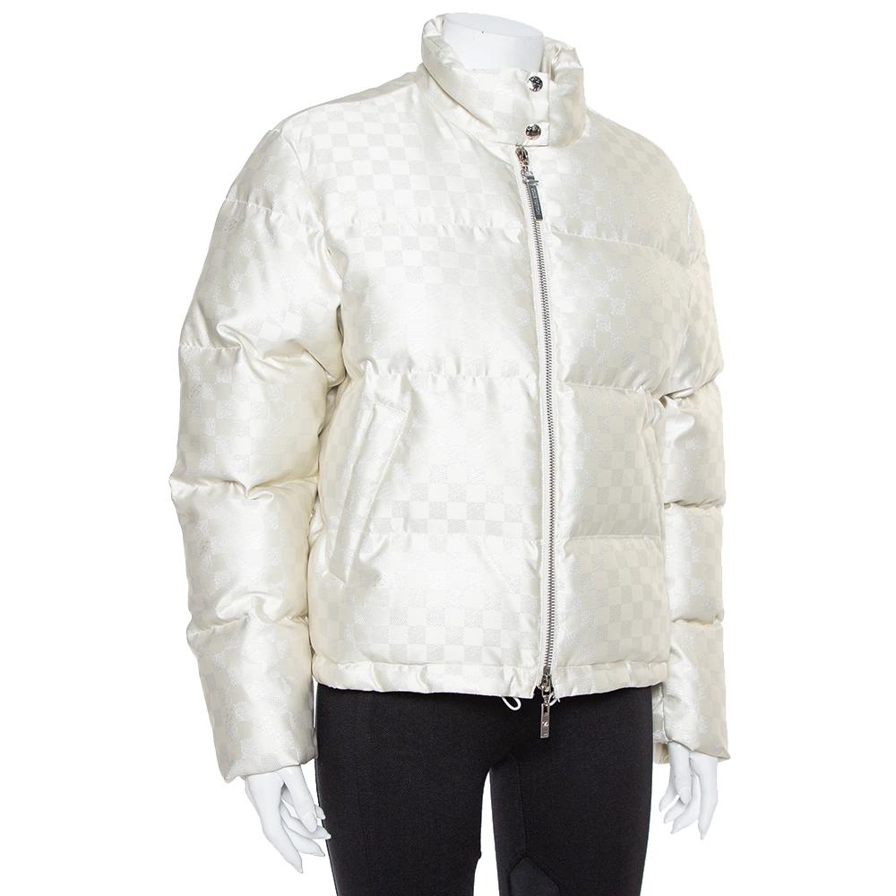 Stay warm in this ultra-stylish puffer jacket by Louis Vuitton. Designed in a fashionable silhouette with the signature Damier pattern all over, the cream quilted jacket, tailored from quality materials, will look great with your winter separates.