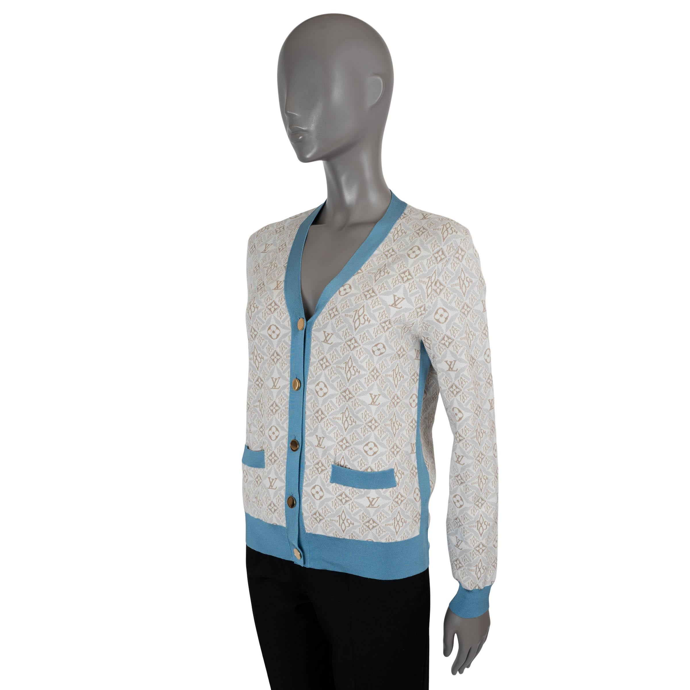 100% authentische Louis Vuitton Strickjacke aus creme- und taupefarbenem 1854-Logo-Jacquard aus Seide (42%), Baumwolle (18%), Polyamid (35%) und Elasthan (5%). Mit blauem Kontrastbesatz, V-Ausschnitt und zwei offenen Taschen an der Taille. Sie wird