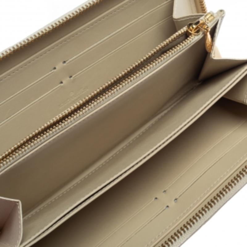 Designed in a cream white hue color, this wallet is a shimmering beauty. Its Monogram Vernis exterior is embossed with the LV signature motifs and features an all-around zip closure. Lined with leather, its interior includes multiple compartments