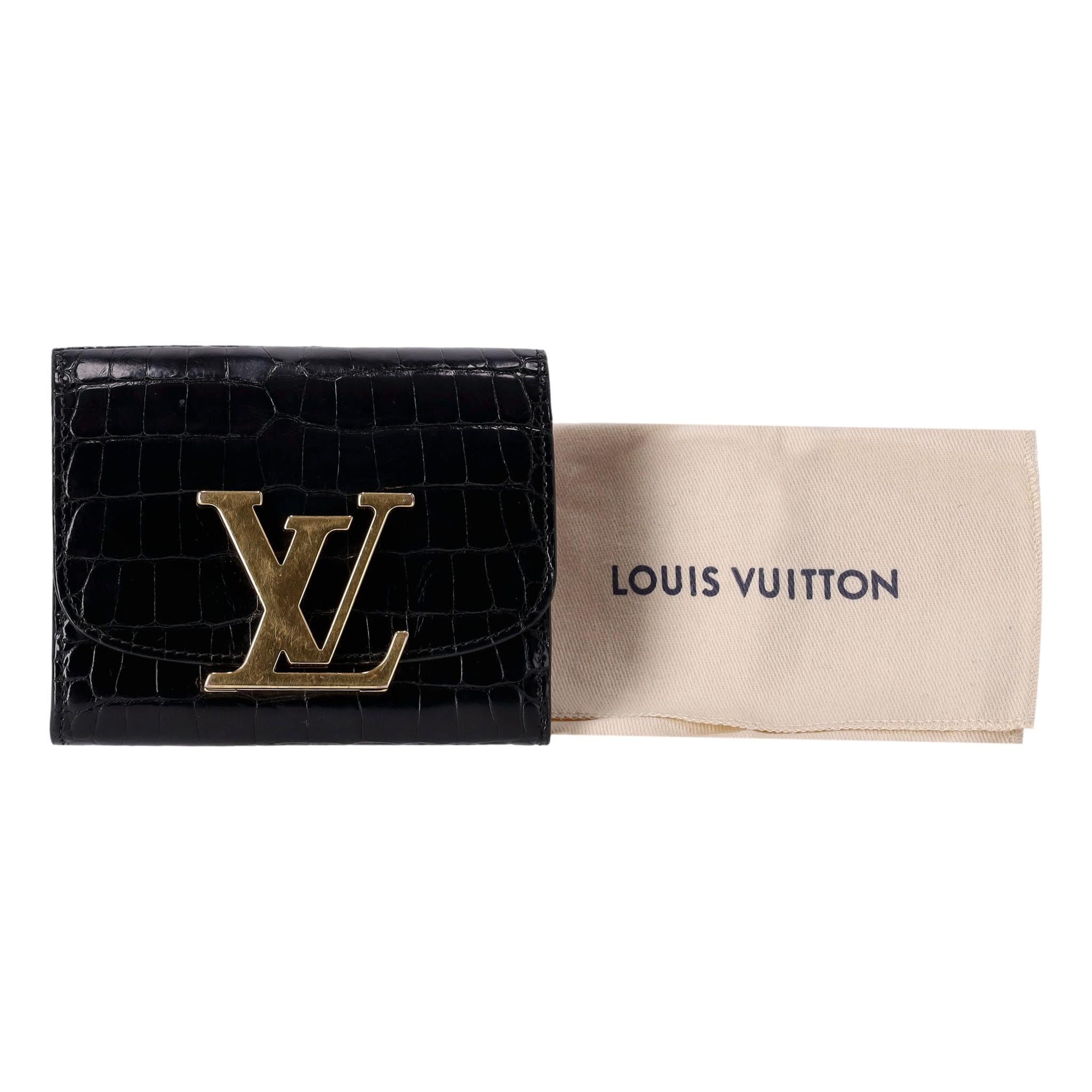 Louis Vuitton Crocodile Skin Capucines Compact Wallet

Black shiny exotic skin purse/wallet with large 'LV' logo closure in gold.

Provides space for credit cards and coins. Current season Rrp £3,950.

Size - Height 10cm, Width 12.5cm, Depth