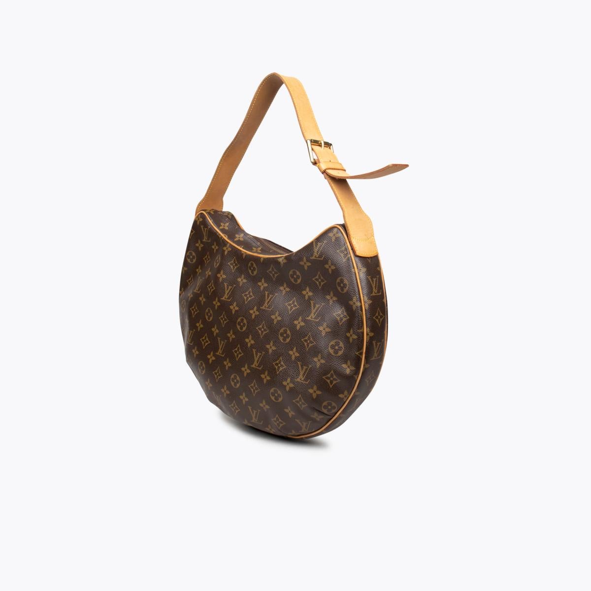 Brown and tan monogram coated canvas Louis Vuitton Croissant GM with

- Brass hardware
- Logo adornment at front
- Single leather adjustable shoulder strap
- Tan vachetta leather trim
- Crimson Alcantara lining, dual slit pockets at interior wall