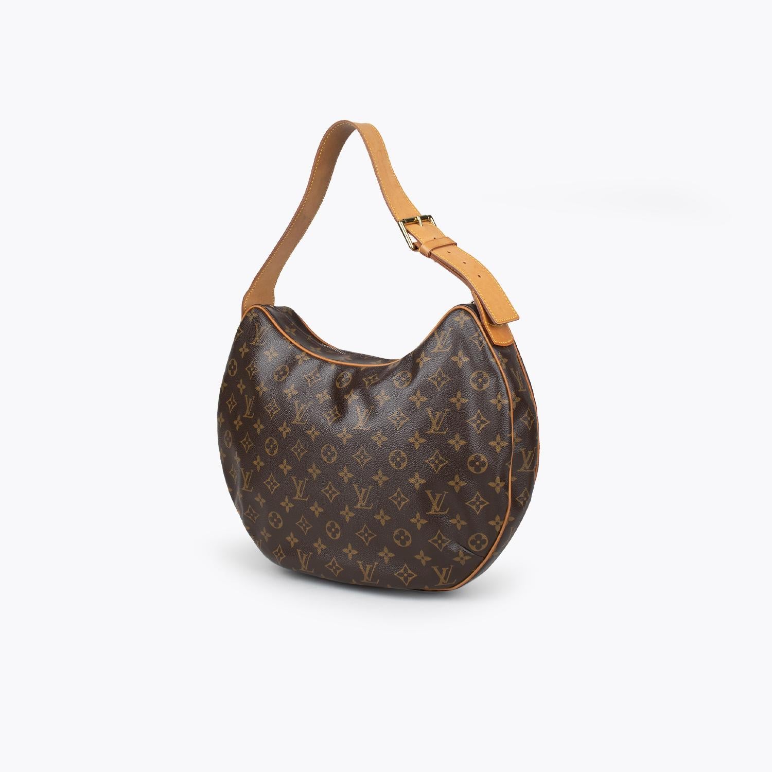 Brown and tan monogram coated canvas Louis Vuitton Croissant GM with

- Brass hardware
- Logo adornment at front
- Single leather adjustable shoulder strap
- Tan vachetta leather trim
- Crimson Alcantara lining, dual slit pockets at interior wall