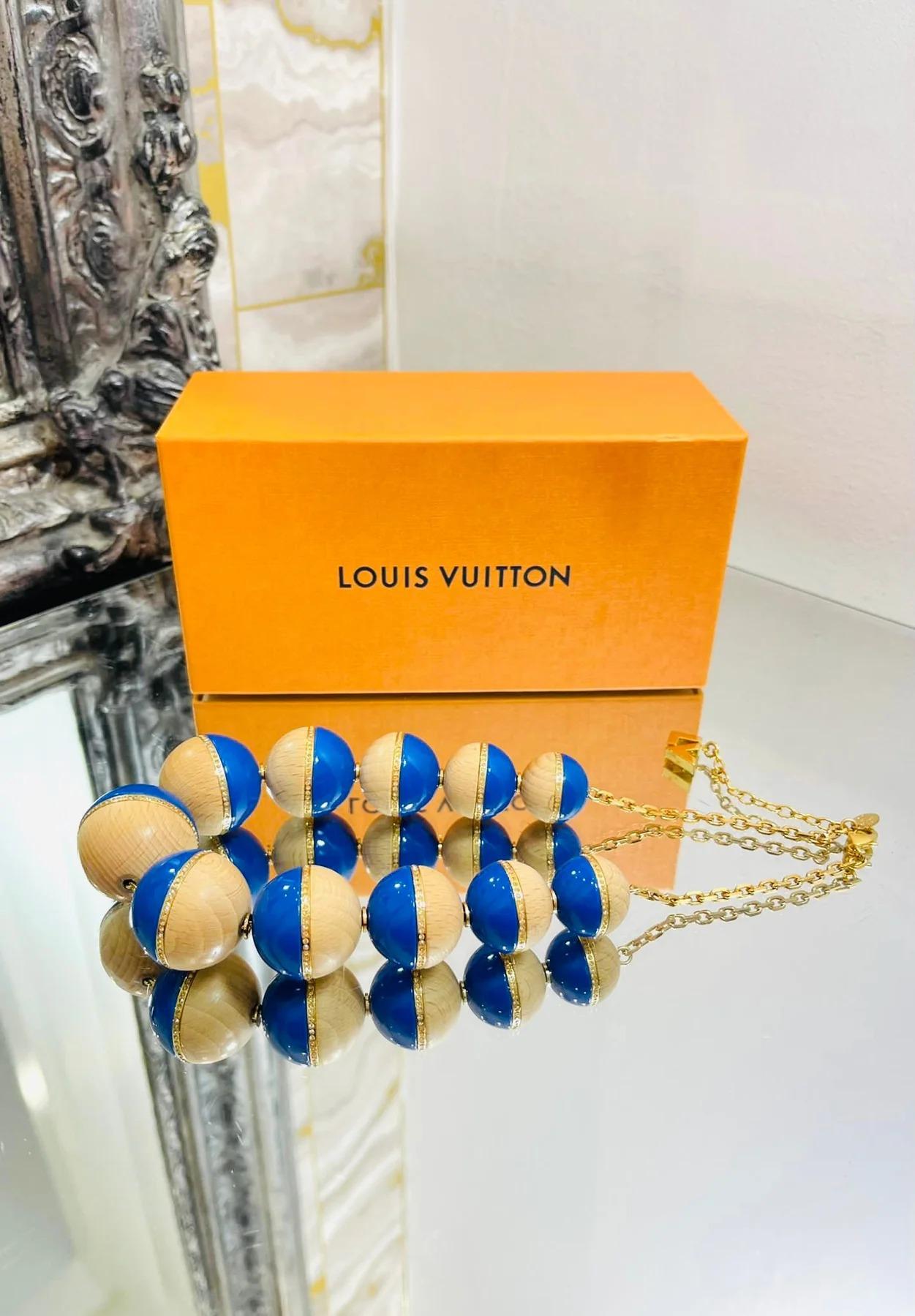 Louis Vuitton, collier de perles en cristal, bois et résine

De grande taille, en résine bleue, en bois avec des ornements en cristal et une chaîne en or. Fermeture avec fermoir en forme de homard et logo 