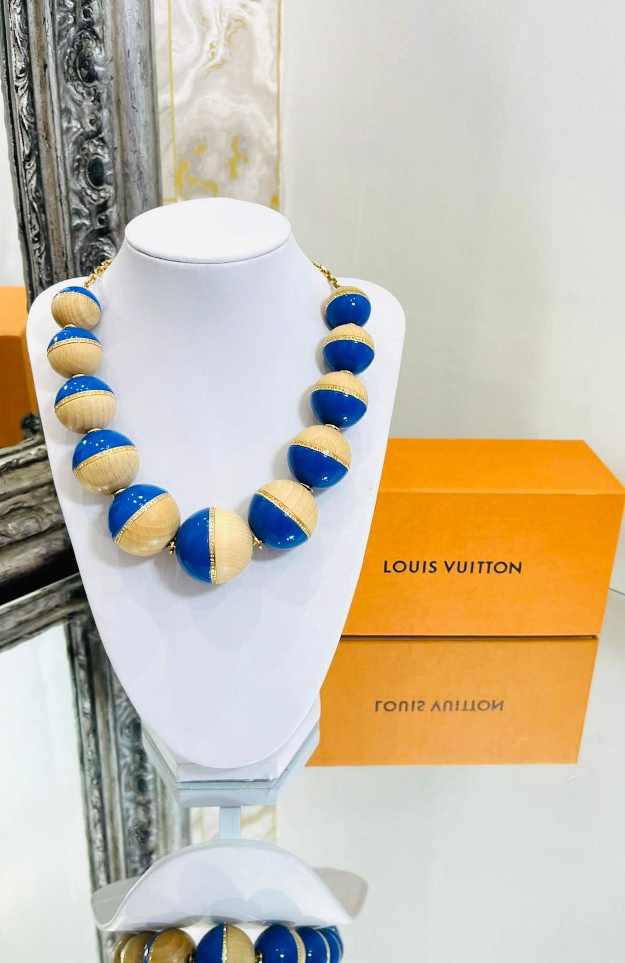 Louis Vuitton Crystal, Wood & Resin Beaded Necklace

Over sized in blue resin, wood with crystal embellishments

and gold chain. Lobster clasp closure with dangling 'LV' logo.

Size - One Size 

Condition - Very Good

Composition - Crystal, Wood,