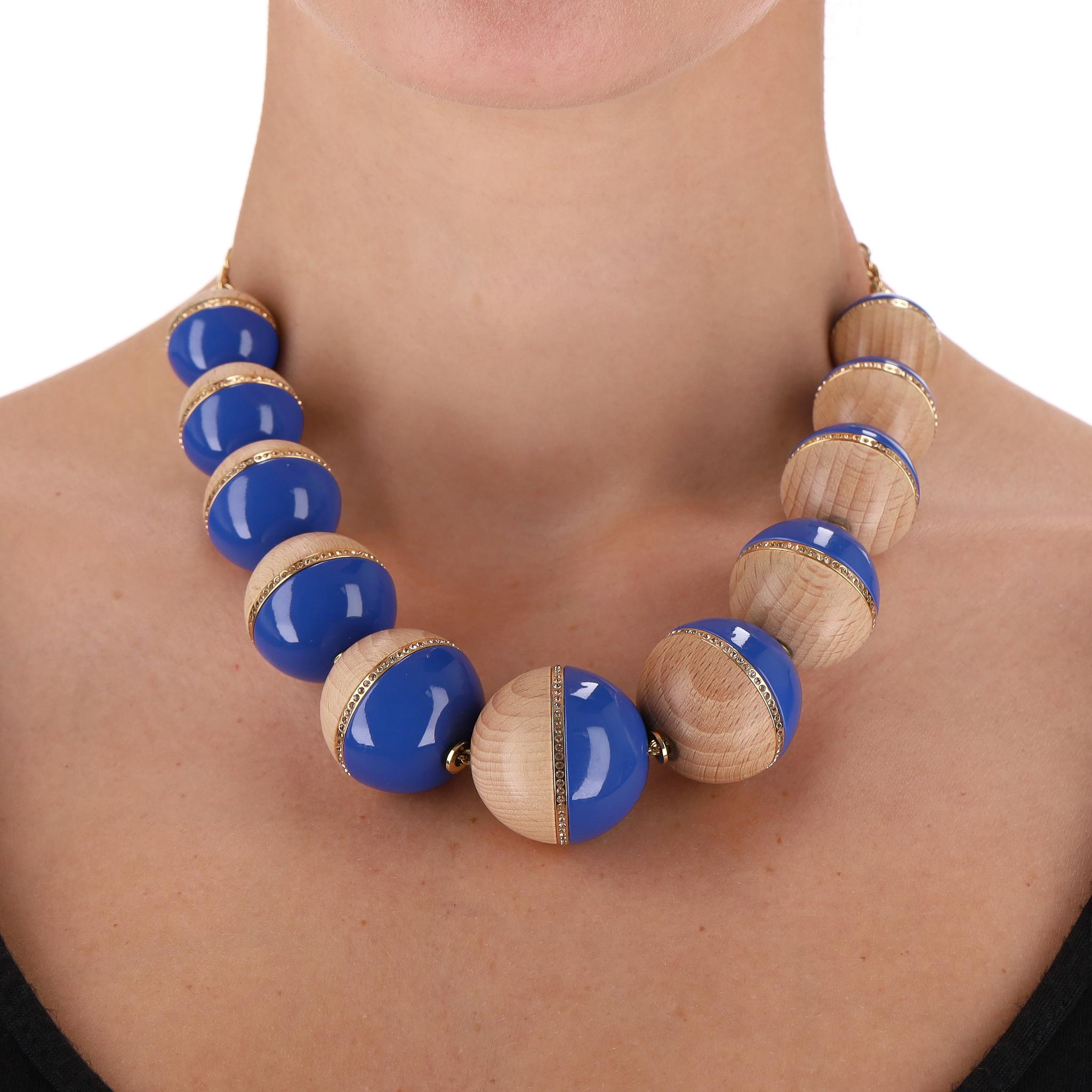 Pièce d'apparat - Louis Vuitton Crystal, Wood & Resin Beaded Necklace

Grand collier de perles sphériques fabriqué à partir d'une combinaison de bois naturel et de résine bleue vibrante, orné d'une fine bande de cristal encerclant le centre de