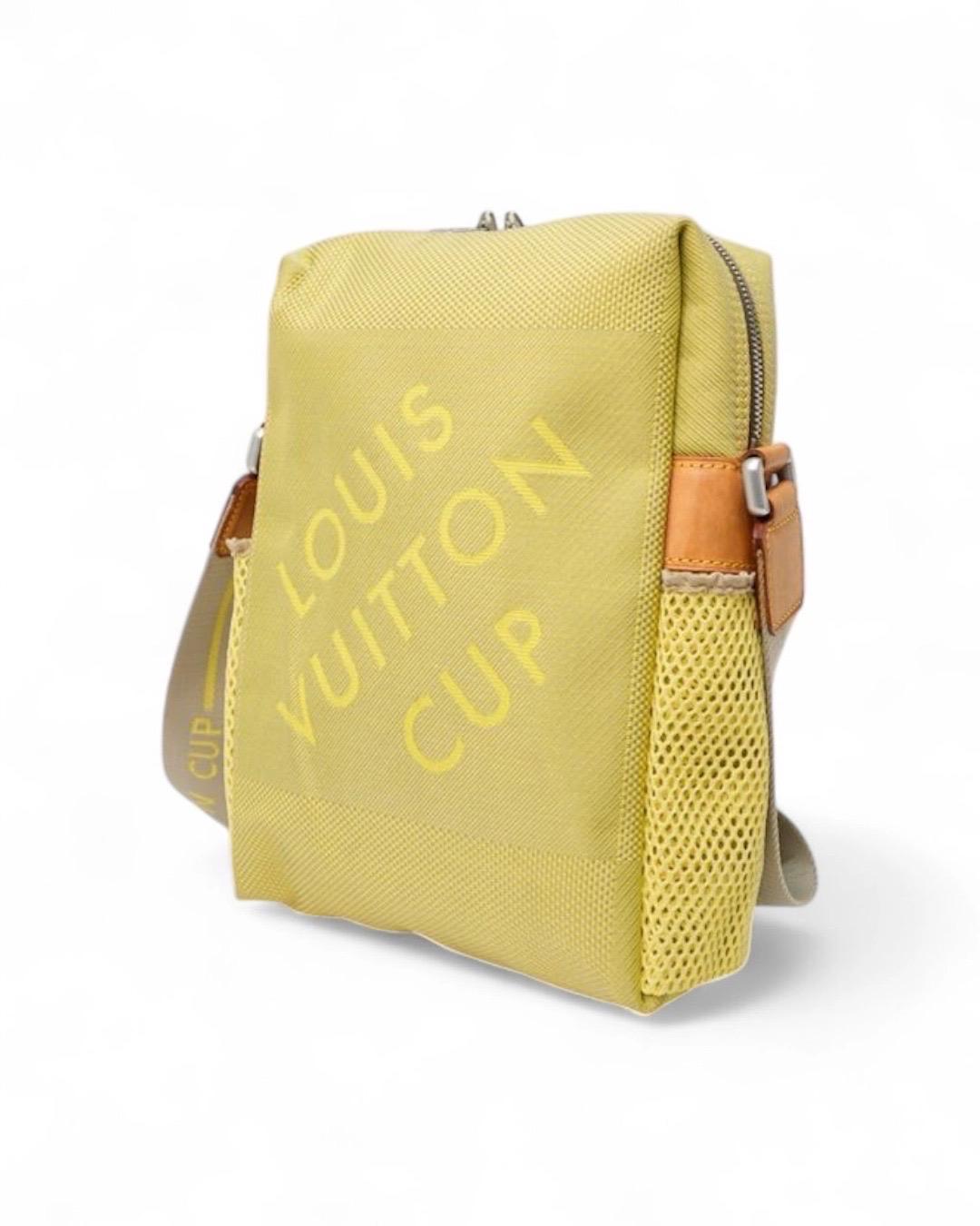 Borsa firmata Louis Vuitton Cup, edizione limitata, modello Weatherly nella misura MM, realizzata in tela Damier Geant nella colorazione giallo fluo con inserti in vacchetta e hardware argento. Dotata di una chiusura semicircolare a zip con doppio