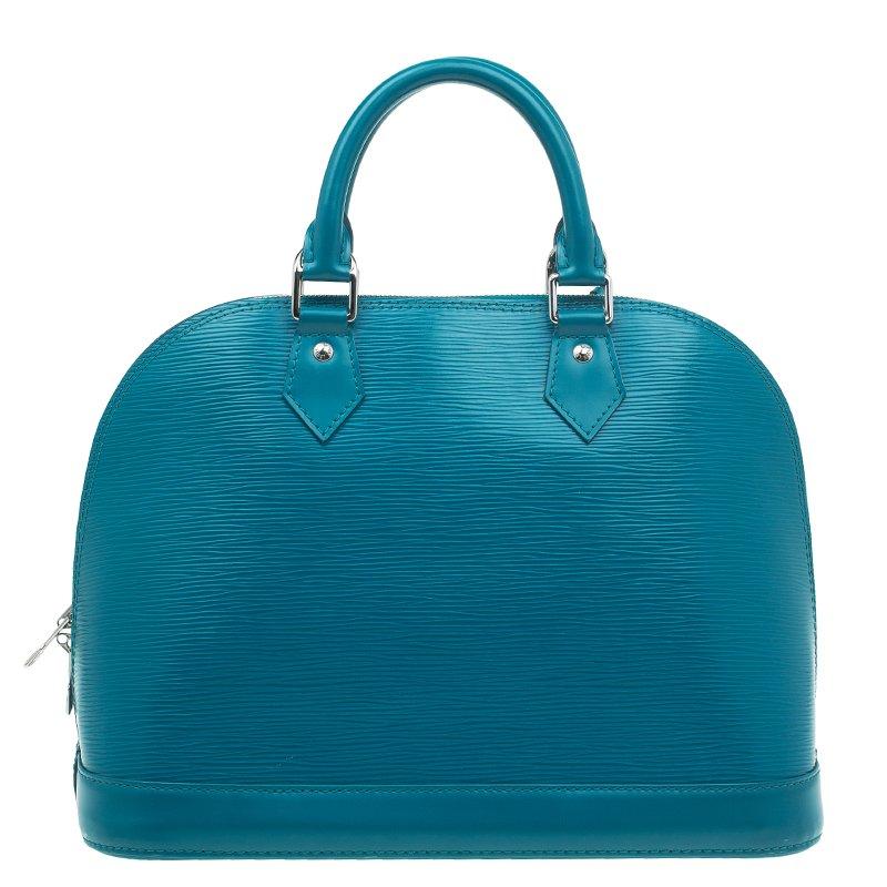 This Alma handbag from Louis Vuitton will surely raise your style statement. Crafted from Epi leather in cyan hue introduced in 2011, this bag features a top zip closure, solid base, leather trim on the exterior leather clochette, key, padlock and