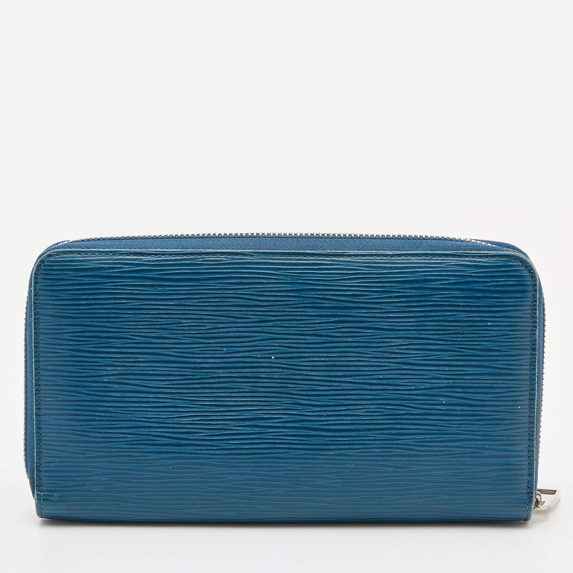 This Louis Vuitton Zippy wallet is conveniently designed for everyday use. Crafted from Cyan Epi leather , it is paired with a zip-around closure and silver-tone hardware. The compartmentalized interior of the wallet will store your card and cash in