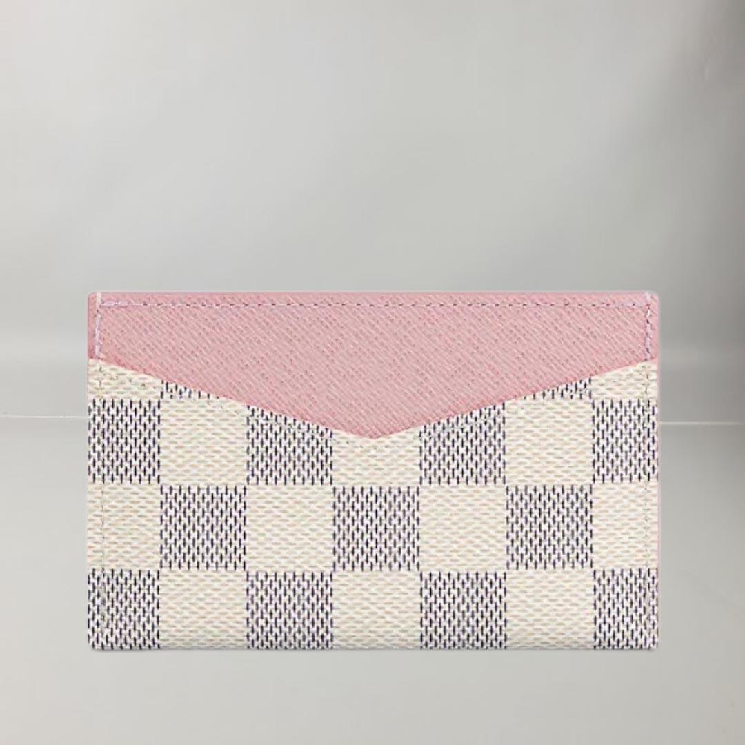 This Daily card holder is made of Damier Azur canvas with a characteristic V cutout on each side that reveals its colored leather lining. Compact, it slips into a pocket or bag. This accessory has two side slots and a large central slot ideal for