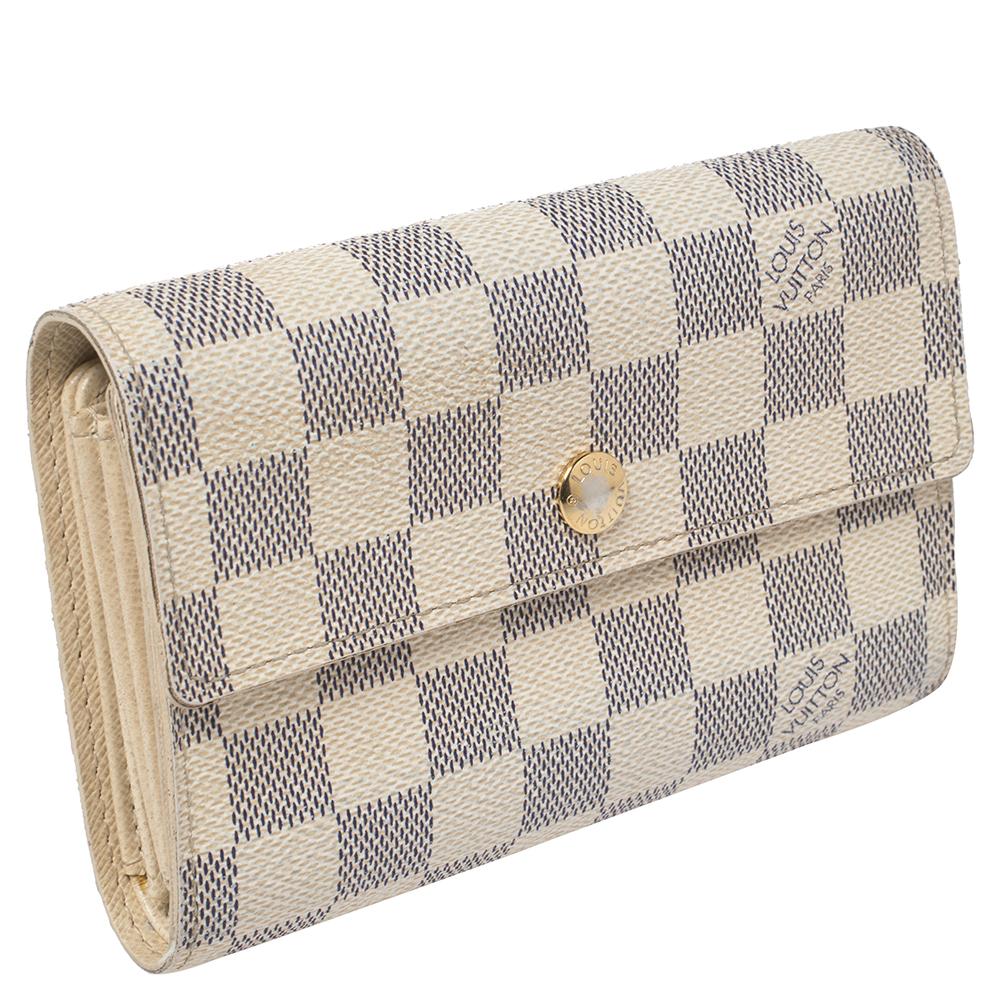 This lovely Alexandra wallet from Louis Vuitton will surely delight your impeccable style. It has been crafted from Damier Azur canvas and designed with a front flap. The leather-lined interior comes with multiple card slots, compartments for your