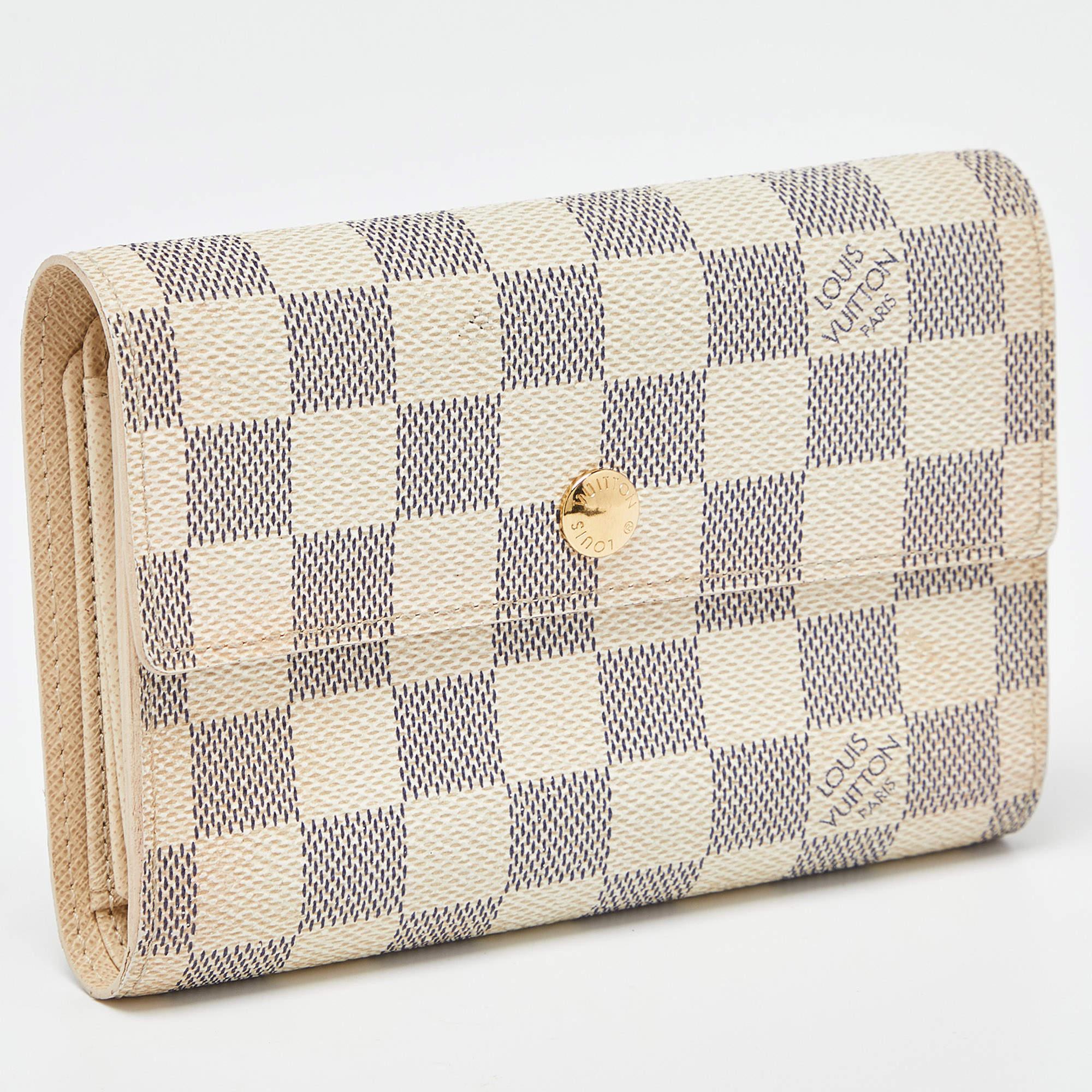 This lovely Alexandra wallet from Louis Vuitton will surely delight your impeccable style. It has been crafted from Damier Azur canvas and designed with a front flap. The leather lined interior comes with multiple card slots, compartments for your