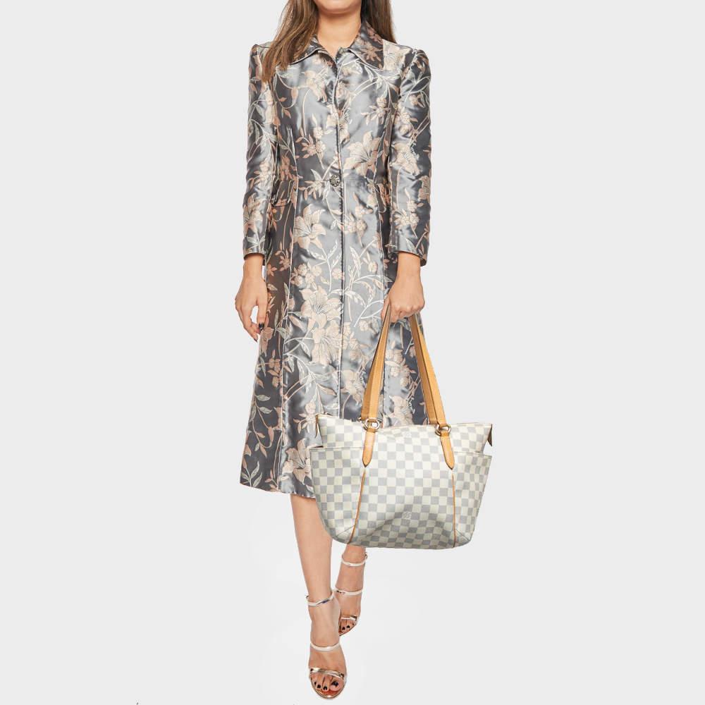 Made from Damier Azur canvas this Totally PM bag by Louis Vuitton exudes just the right amount of sophistication. The bag has two handles a top zipper and a capacious canvas interior. It has additional open pockets on the sides of the exterior and