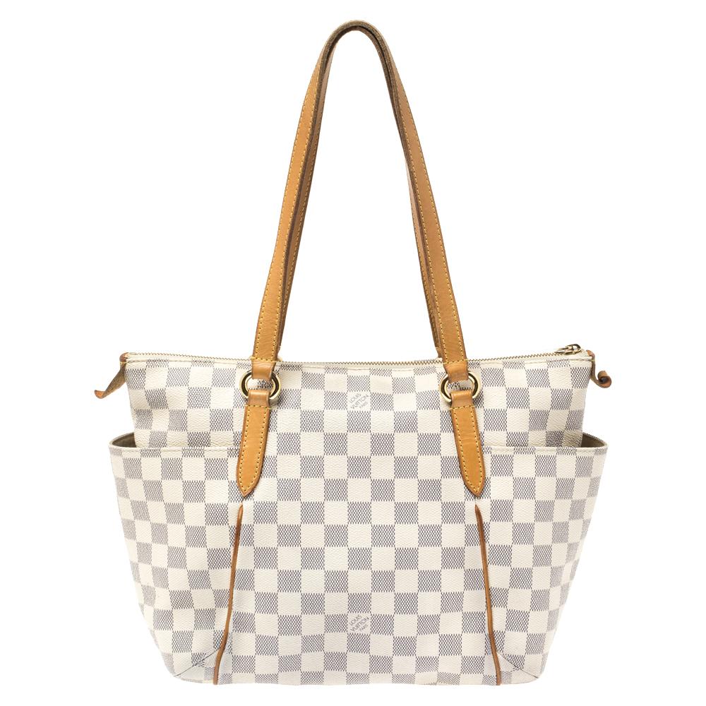 Made from Damier Azur canvas, this Totally PM Bag by Louis Vuitton exudes the right amount of luxury. The bag has two leather handles, a top zipper, and a capacious canvas interior. Also, it has additional open pockets on the sides of the exterior