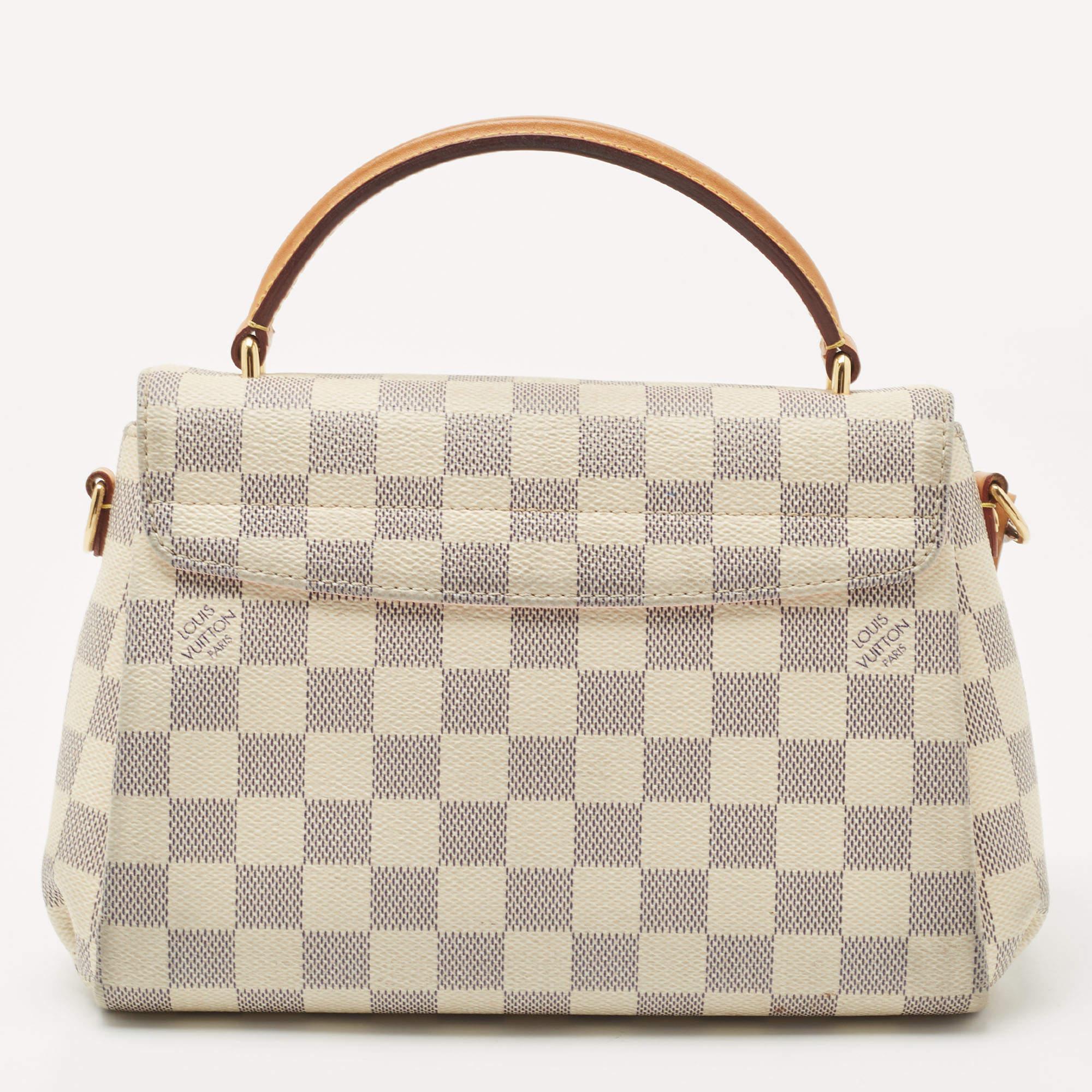 Treat yourself with this Croisette bag by Louis Vuitton. This structured style is crafted from signature Damier Azur canvas. It is detailed with a logo-engraved lock in gold-tone hardware, a top handle, and a slender shoulder strap for crossbody