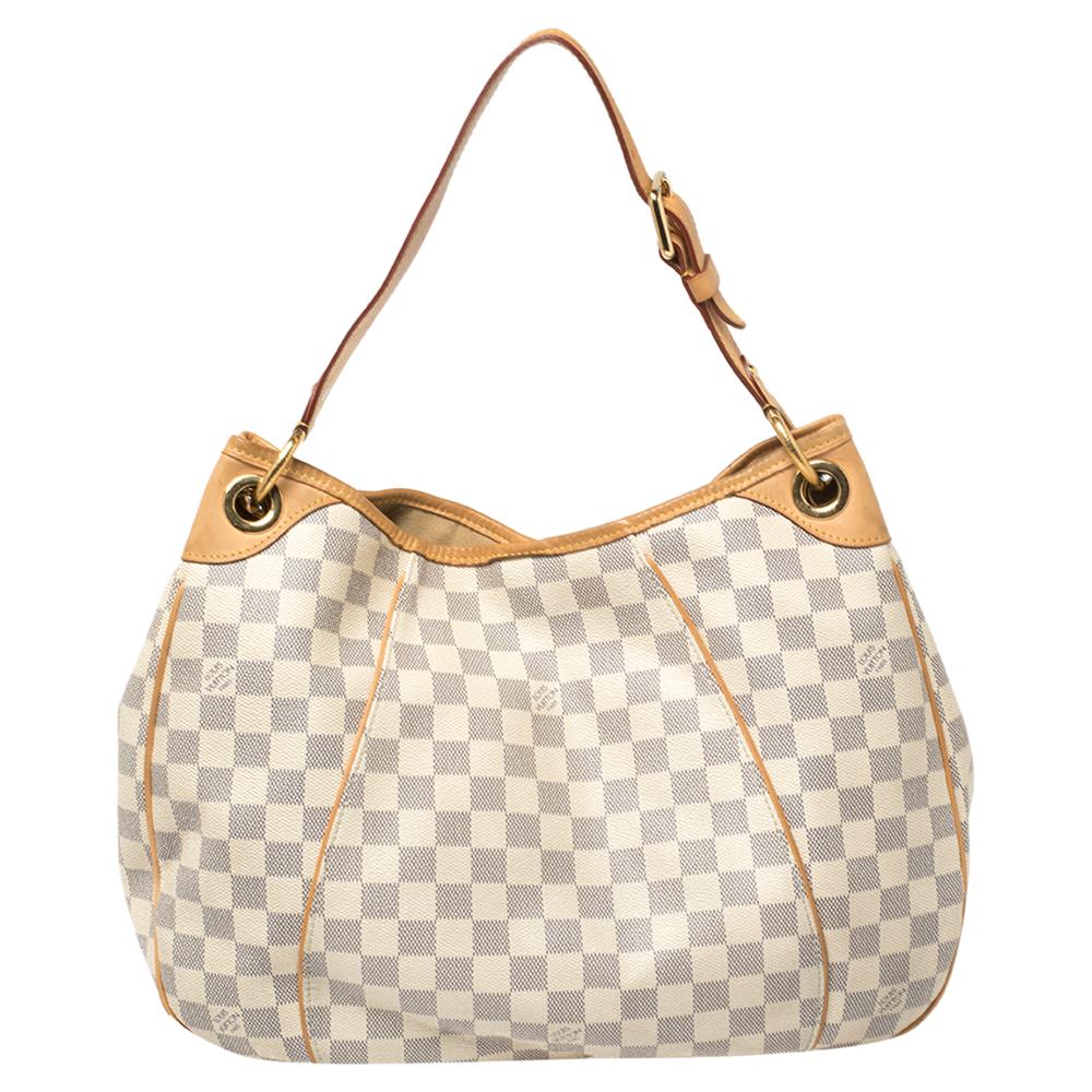 Your dream to own a classic Louis Vuitton handbag has come true in this gorgeous Galliera PM. Crafted from Damier Azur canvas and leather, this bag features a single handle, a snap button, and gold-tone hardware. While the front brand plaque