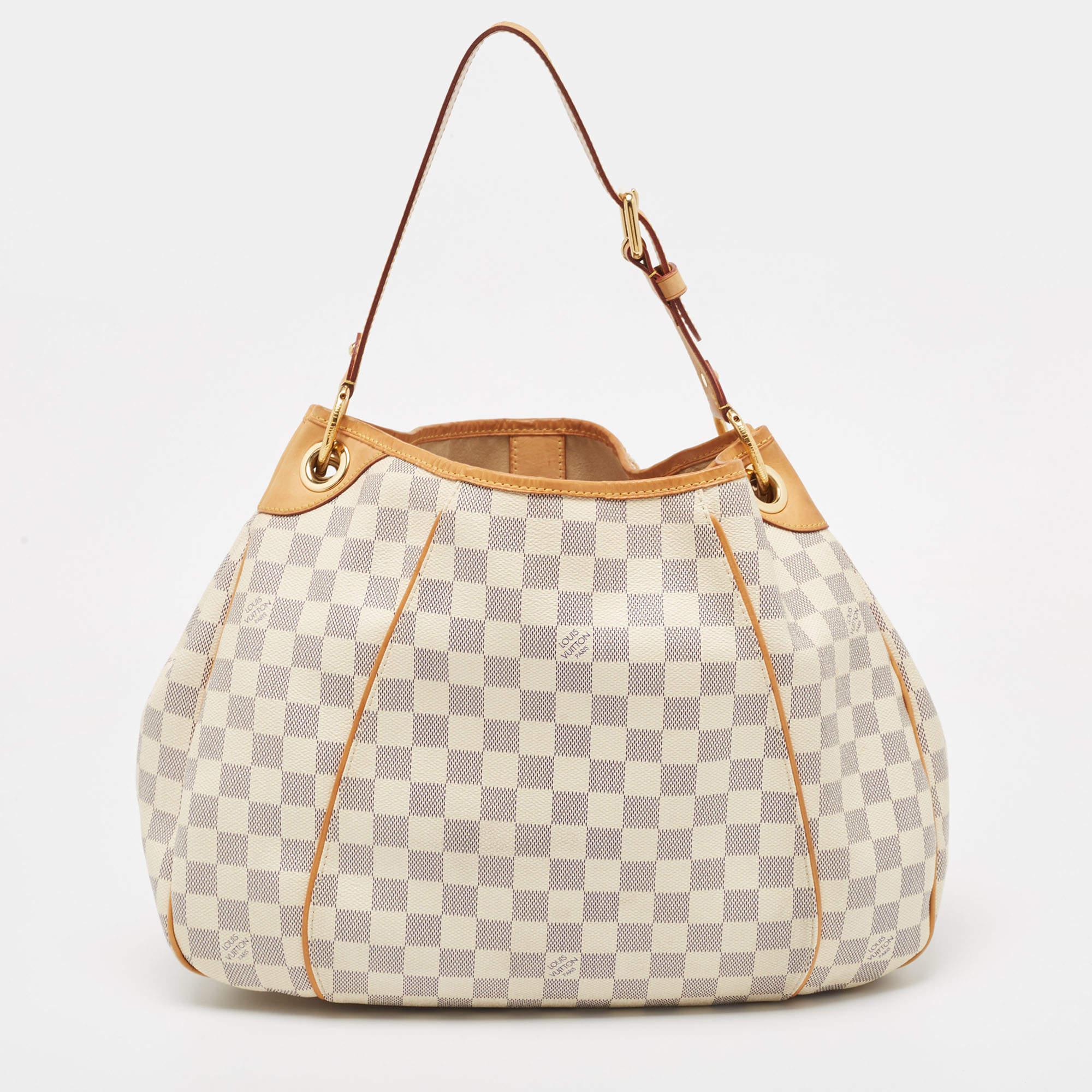 Add this Galliera bag by Louis Vuitton to your collection today! It is crafted with the signature Damier Azur canvas and leather on the exterior. It comes with a single handle, a snap button, and gold-tone hardware. The Louis Vuitton Inventeur plate