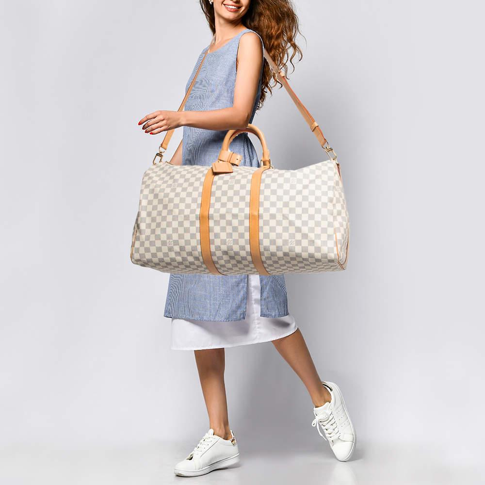 Crafted in iconic Damier Azur canvas the Louis Vuitton Keepall Bandouliere 55 Bag exudes timeless charm. Its spacious interior accommodates essentials with ease while the adjustable shoulder strap ensures effortless carrying. Perfect for the modern