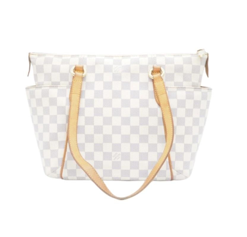 Ivory and navy Damier Azur coated canvas Louis Vuitton Totally PM with gold-tone hardware, tan vachetta leather trim, dual flat shoulders straps, dual slit pockets at exterior, neutral canvas lining, dual slit pockets at interior walls and zip