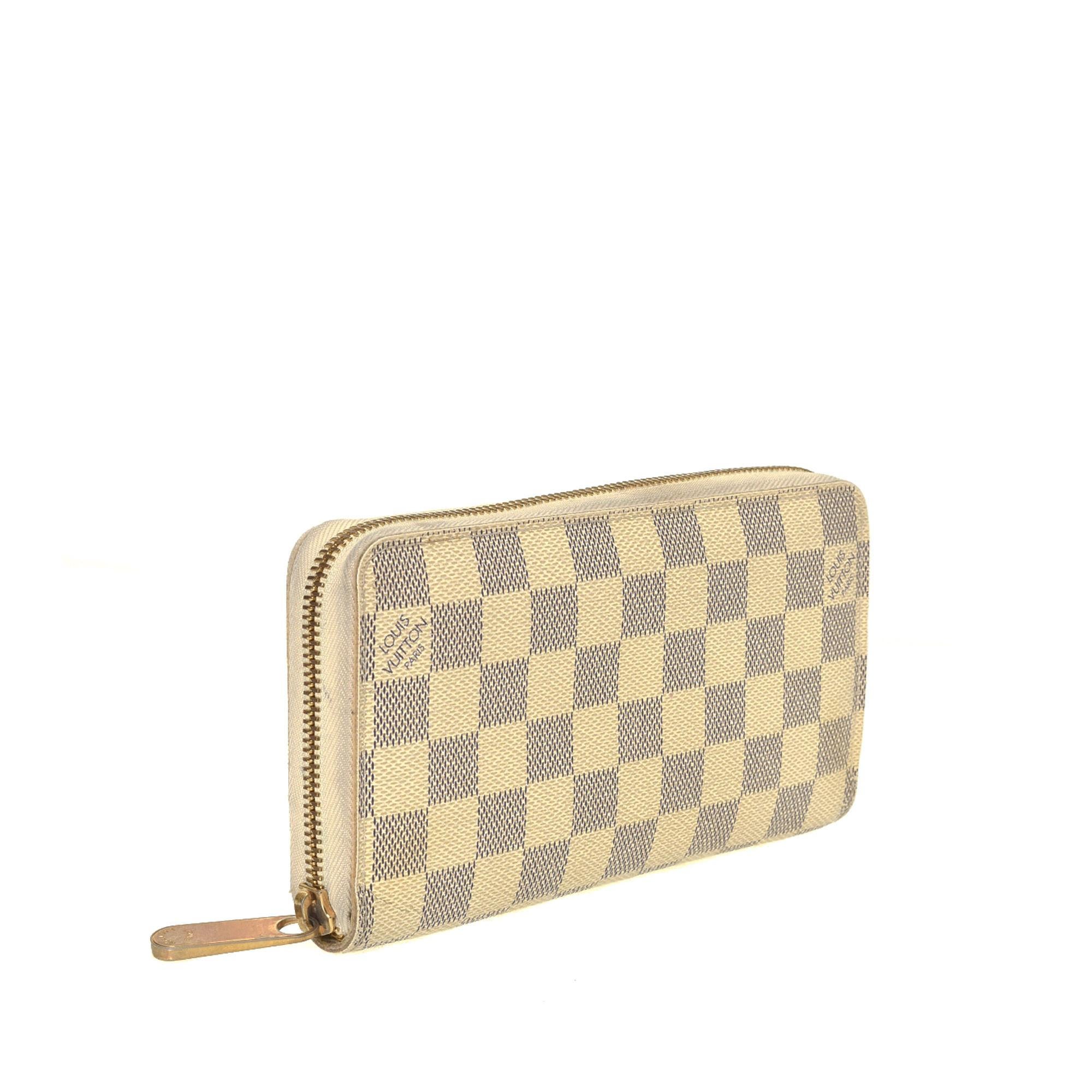 Ivory and navy blue Damier Azur coated canvas Louis Vuitton Zippy wallet with ivory Taiga leather lining, gold-tone hardware, five interior compartments; one with zip closure, dual bill compartments, eight card slots and zip-around closure at